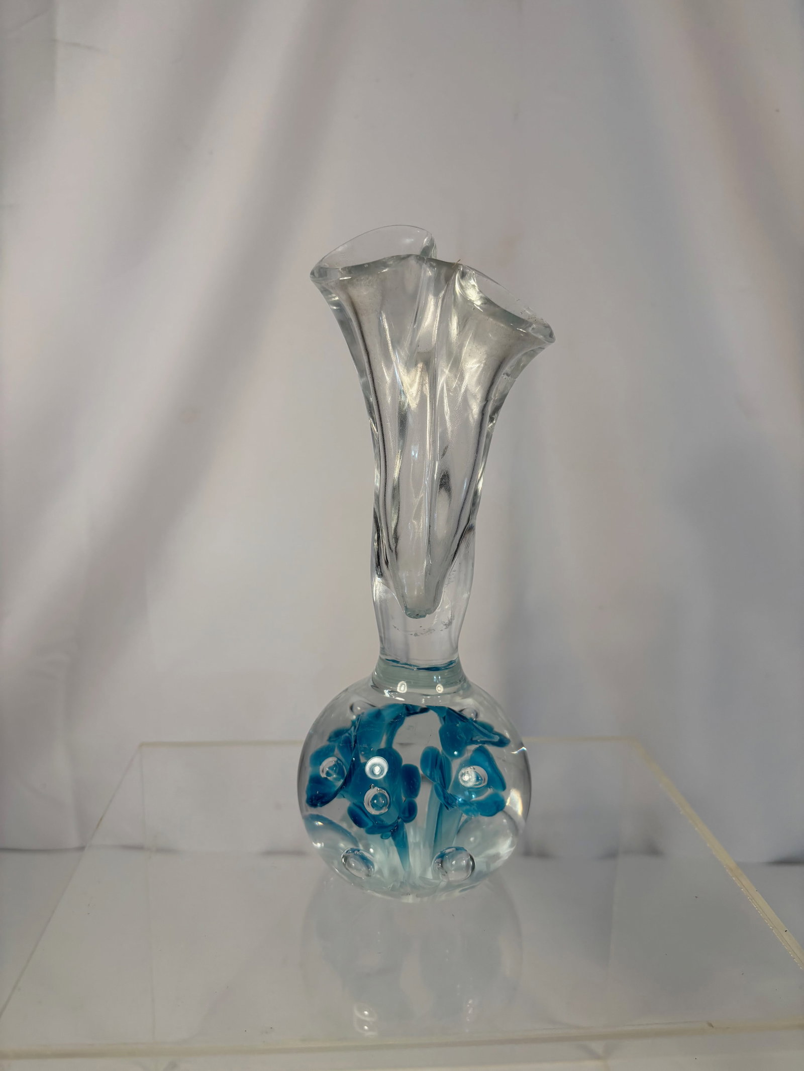 A Gibson Art Glass Vase with Encased Blue Floral Design, Signed and Dated 1998: A beautiful Gibson Art Glass studio vase, signed and dated “Gibson 1998” on the base. The piece features a rounded clear crystal body with encased blue and white floral inclusions and controll