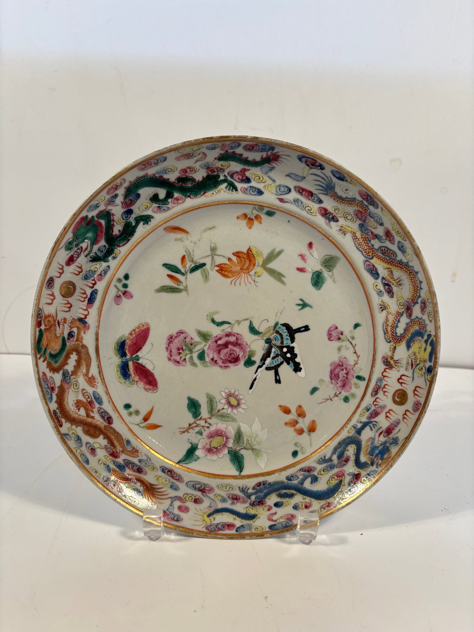 A Chinese famille rose porcelain round plate: Qing Dynasty (1644-1912), Features flowers, insects, and several large, vividly colored butterflies. Dimensions?Diameter: 10 inches; Height: 2 inches