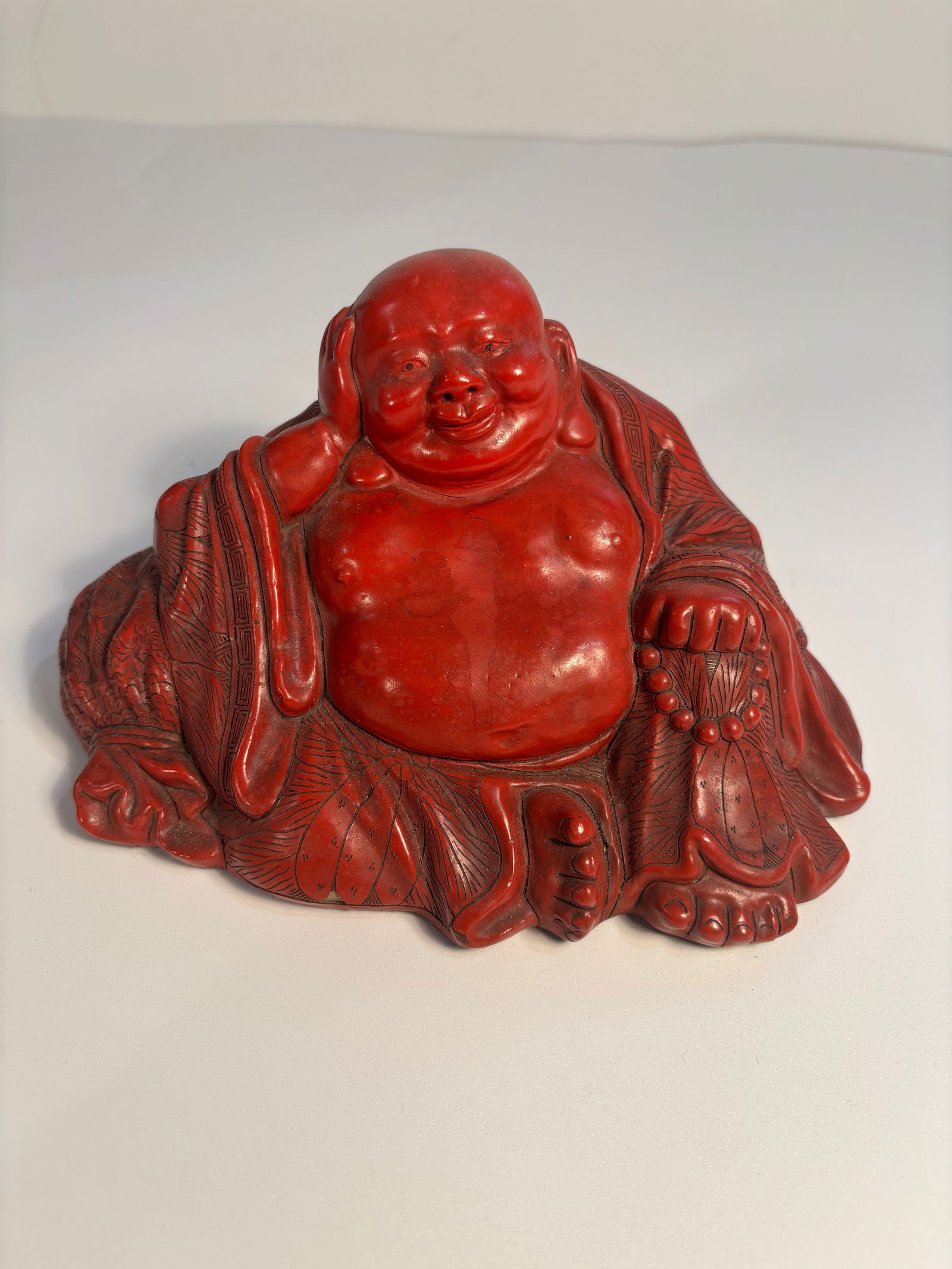 A Big Chinese red Lacquer laughing Buddha: Qing dynasty (1644-1912); The fine details in the robes and expression suggest skilled carving.There is a "CHINA"mark at the bottom. Dimensions?Height:4 inches ; Length: 7.5inches.