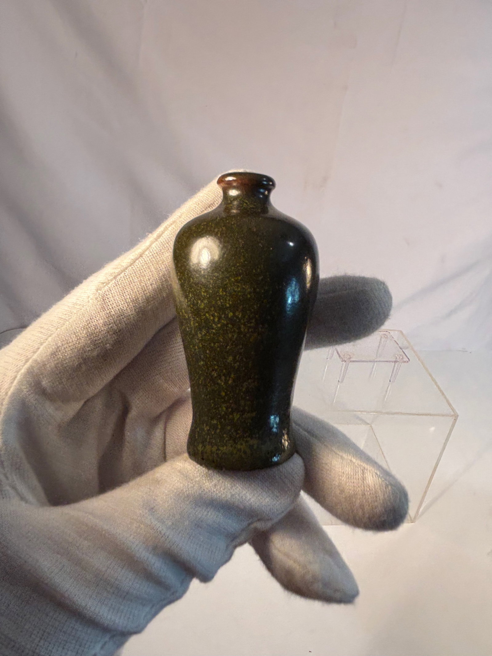 A Chinese Small Tea-Dust Glazed Porcelain Vase, Meiping Form, 19th century: A small porcelain vase in tea-dust glaze, Of meiping form with rounded shoulders and narrow neck, the body covered overall in a finely speckled olive-green glaze imitating Qing dynasty tea-dust wares.