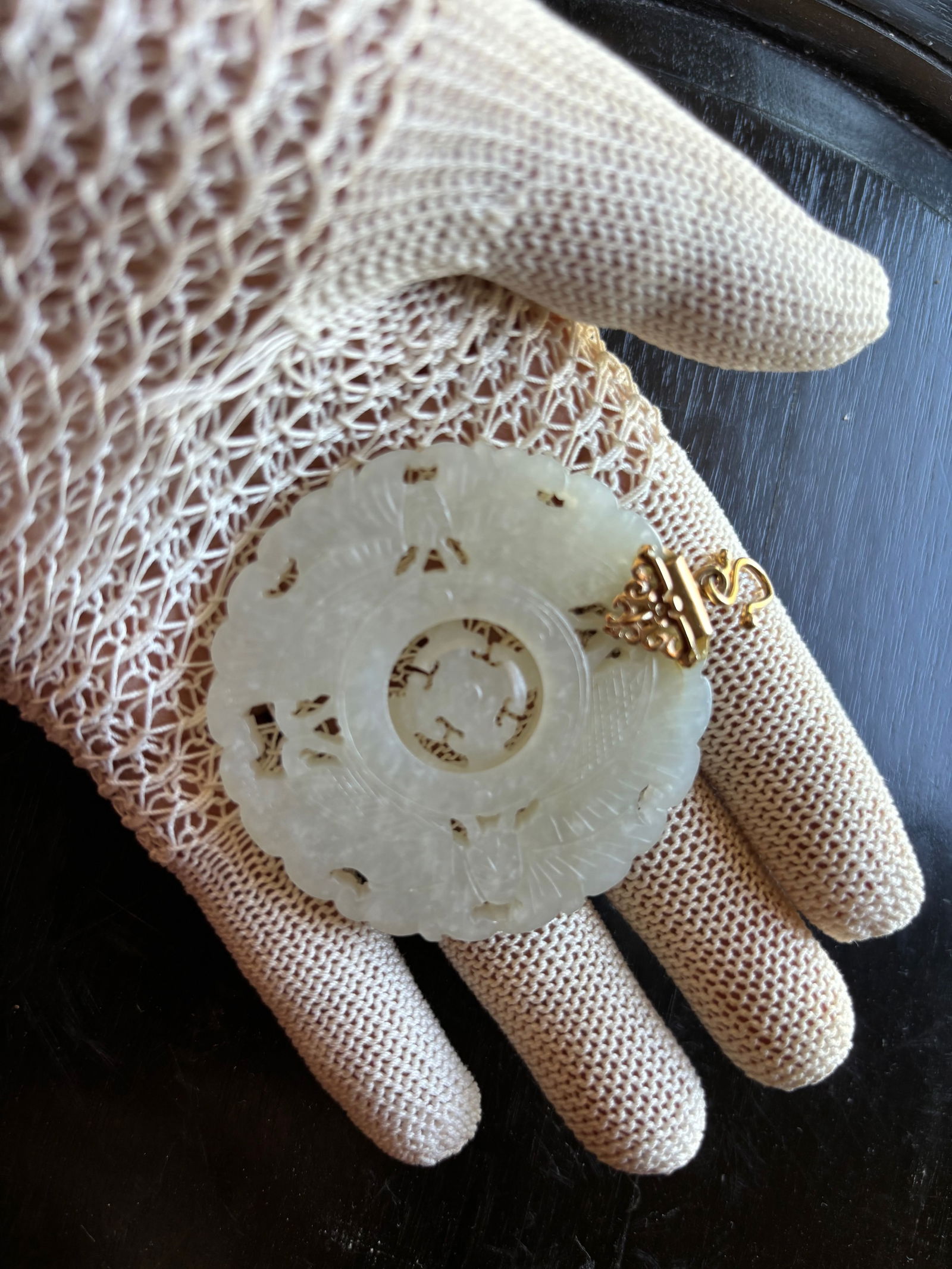 A Chinese White Jade Medallion Pendant with 14 k Gold Mount: Qing Dynasty (1644-1912); A circular Chinese white jade pendant finely carved with auspicious motifs. The pendant features a rotating inner disc, a design sometimes symbolizing harmony or cosmic motio