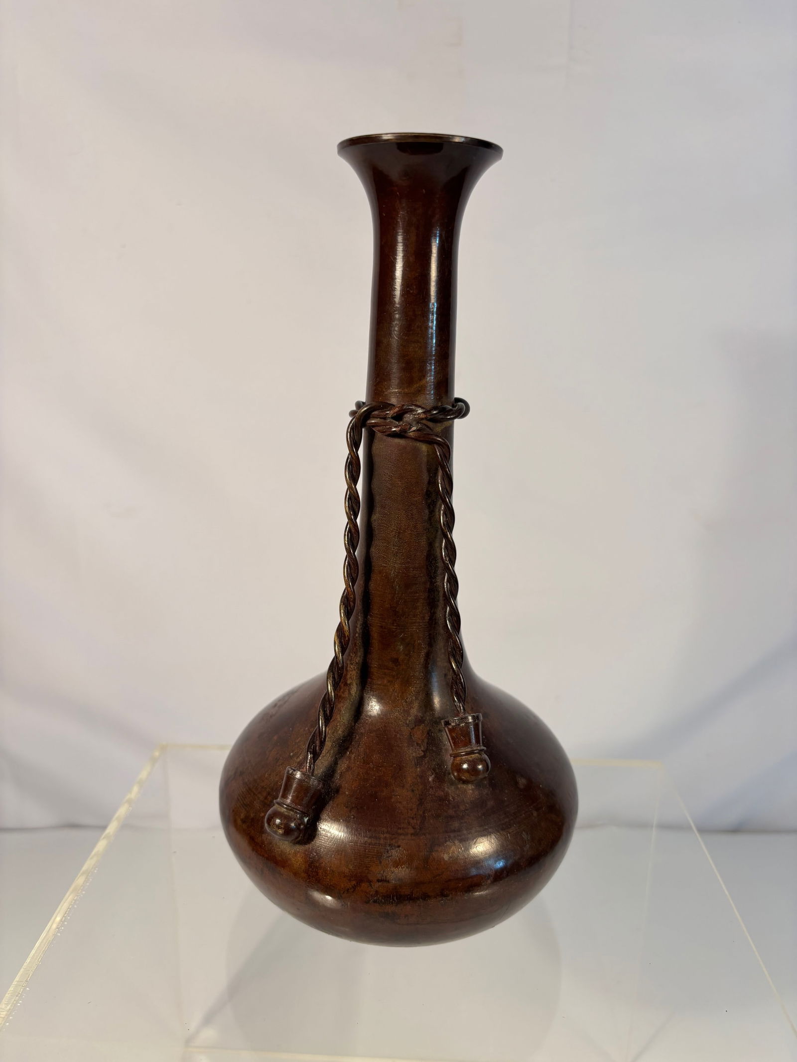 A Japanese Brown-Glazed Bottle Vase with Applied Chain Decoration: Early 20th century, Japanese brown-glazed ceramic bottle vase, the elongated neck with applied mock chain links suspended from relief rings at the shoulder, a technical flourish demonstrating potter��