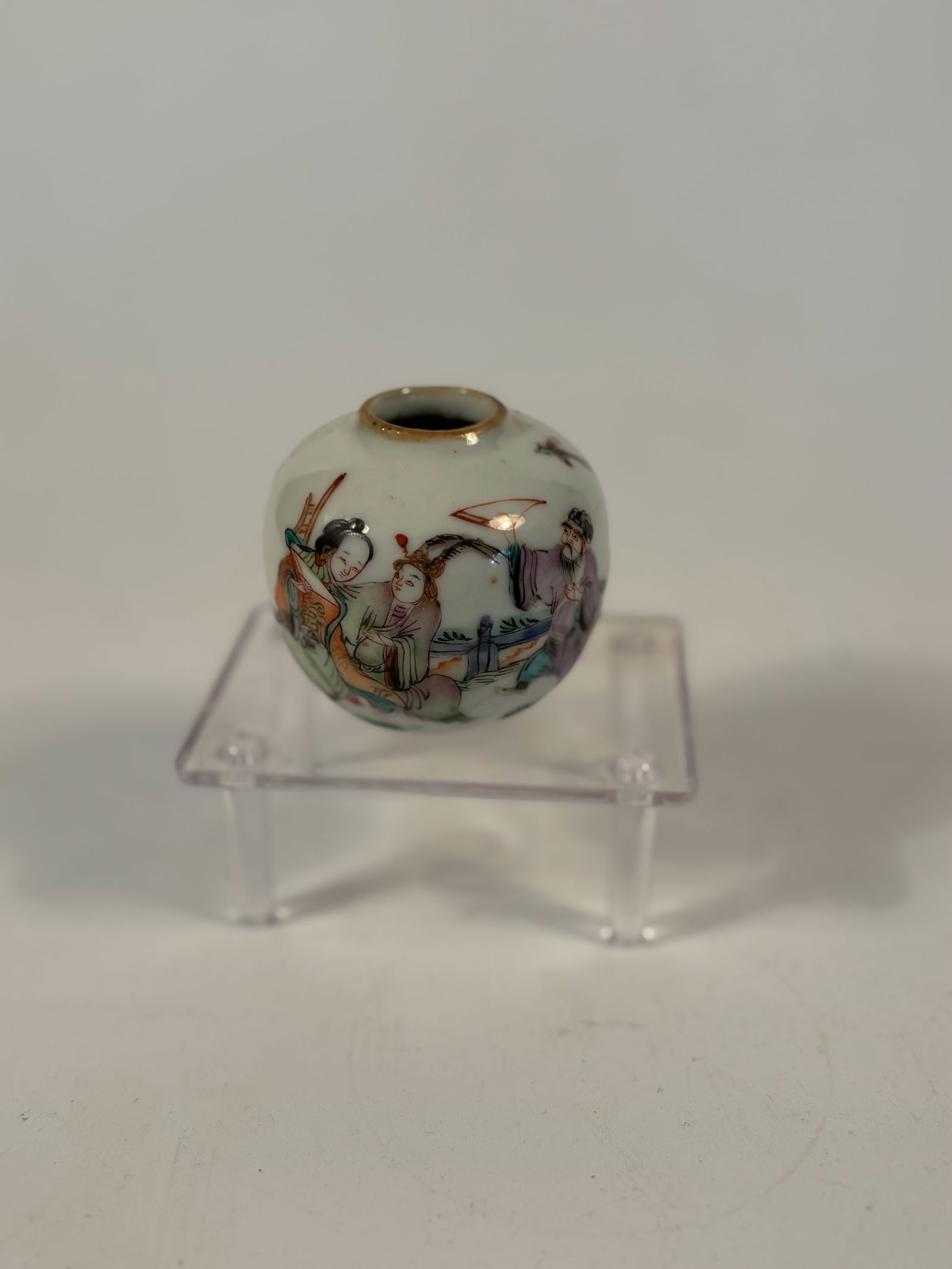 A Chinese famille rose porcelain water pot: Qing dynasty(1644-1912);This small, rounded vessel is hand-painted in soft enamel tones with an elegant figural scene depicting courtly scholars and attendants in a garden setting. The figures are ren