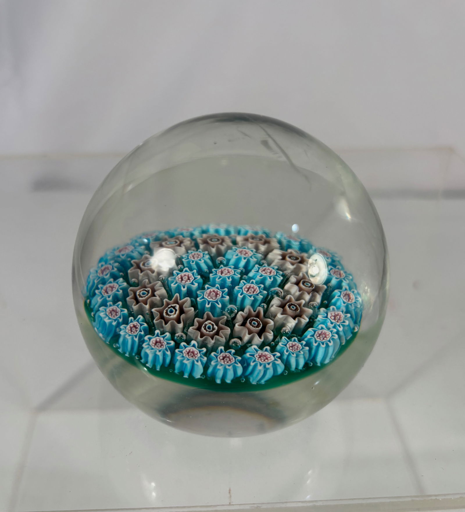 Art Glass Millefiori Paperweight with Multicolor Floral Canes: Art glass millefiori paperweight featuring a dense arrangement of multicolor floral canes in shades of turquoise blue, white, pink, and brown, set beneath a clear glass dome. The canes are well define