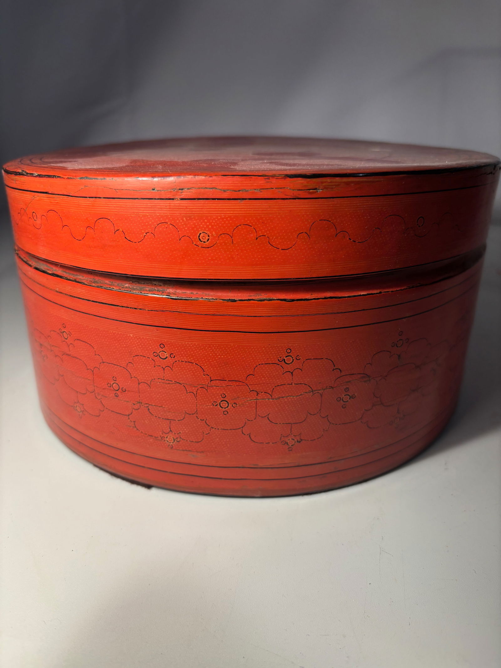 A Burmese (Myanmar) Lacquered Bamboo “Kun-it?? Box with inside tray , 19th century: A Burmese (Myanmar) lacquered bamboo kun-it box, traditionally used for storing betel nut and related condiments. The circular form is finished in red lacquer with incised linear and foliate decoratio
