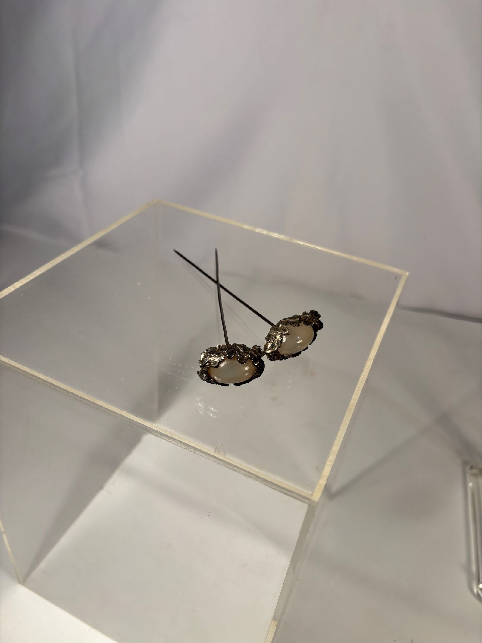 Pair of Silver-Mounted Moonstone Hairpins: 19th century, Pair of silver hairpins each set with an oval moonstone cabochon displaying soft adularescence. Traditional straight-pin form, suitable for hair ornamentation. Stones with natural