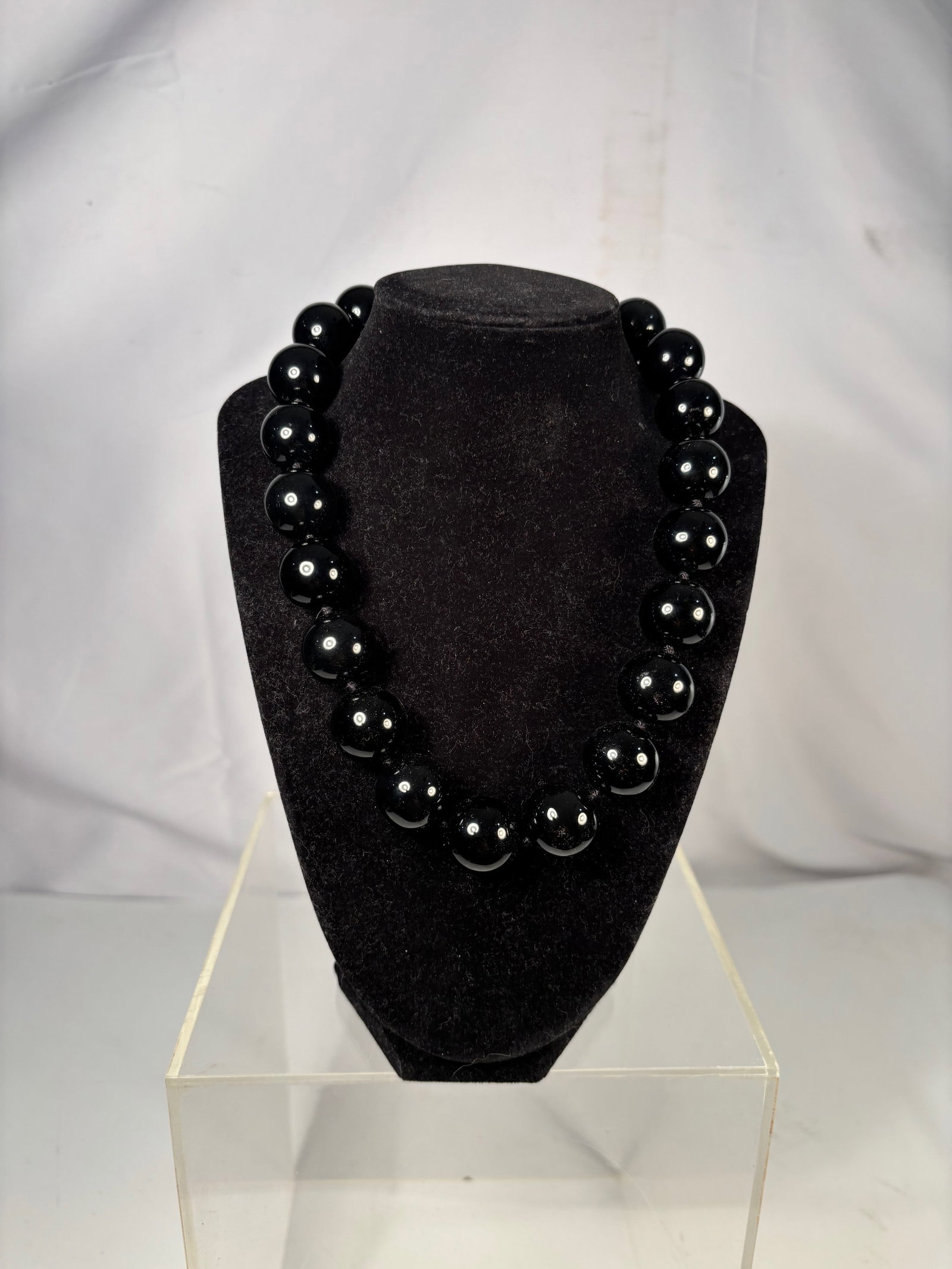 A Vintage Large Black Onyx Bead Necklace with 925 Silver Intaglio Clasp: Strand necklace composed of large polished black onyx beads, each individually knotted, centered with an oval black onyx intaglio clasp engraved with a monogram and mounted in sterling silver marked 9