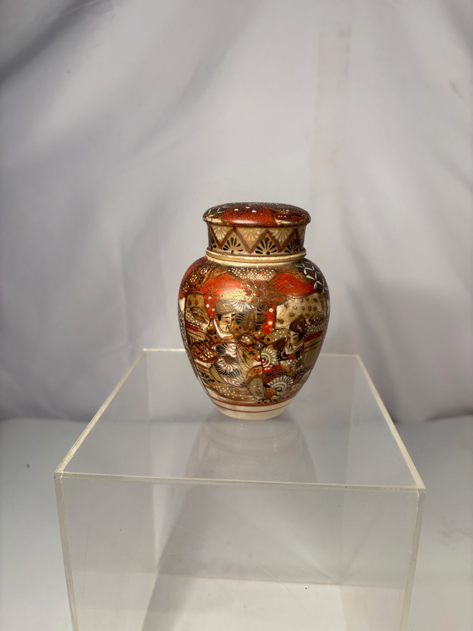 A Japanese Satsuma Style Miniature Covered Vase w/ Figural Decoration: Japanese Satsuma-style miniature covered vase, finely decorated with polychrome enamel and gilt detailing. The body features figural scenes of scholars and attendants, surrounded by intricate geometri