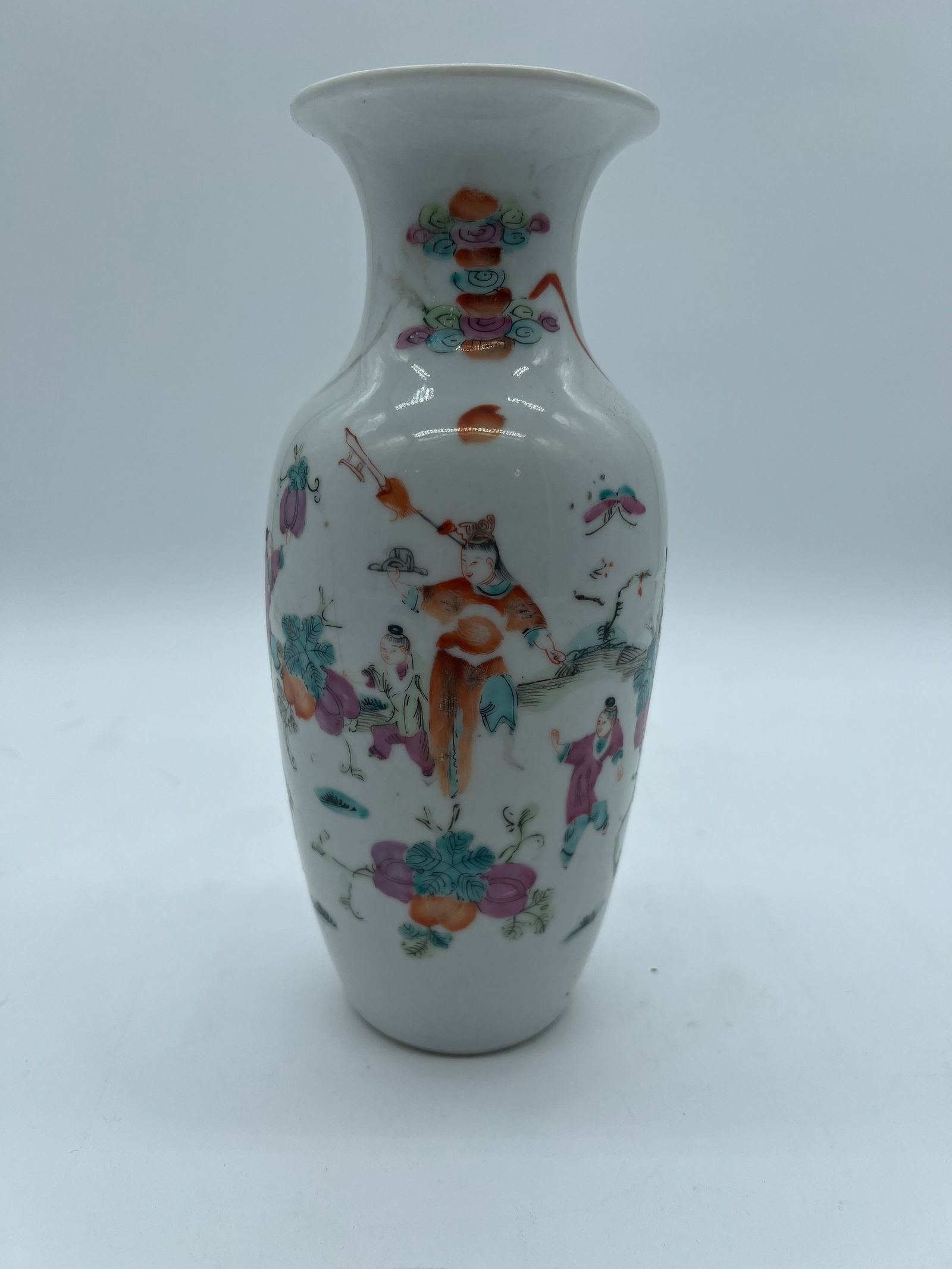 A Chinese Famille rose porcelain vase with red iron mark.: Qing dynasty (1644-1912); The vase features colorful enamel painting depicting figures in traditional Chinese attire, possibly children or attendants. The vibrant pinks, greens, and oranges are charac