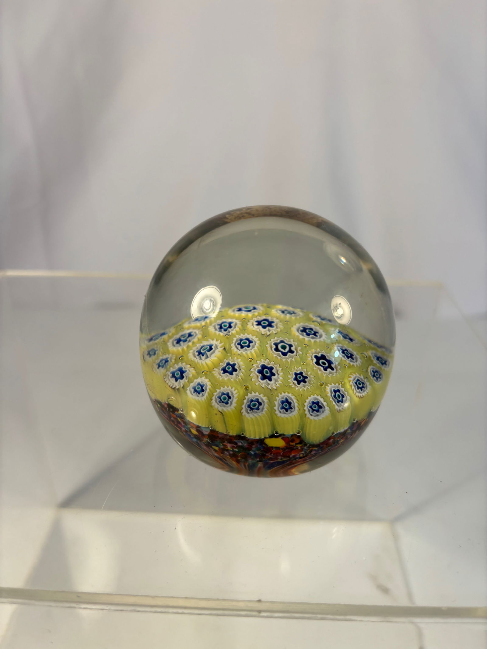 Italian Murano Millefiori Paperweight with Yellow Ground, Mid-20th Century: Of domed circular form, the interior filled with concentric rows of multicolored millefiori canes on a bright yellow ground, viewed through a clear glass dome. The underside with a polished pontil and