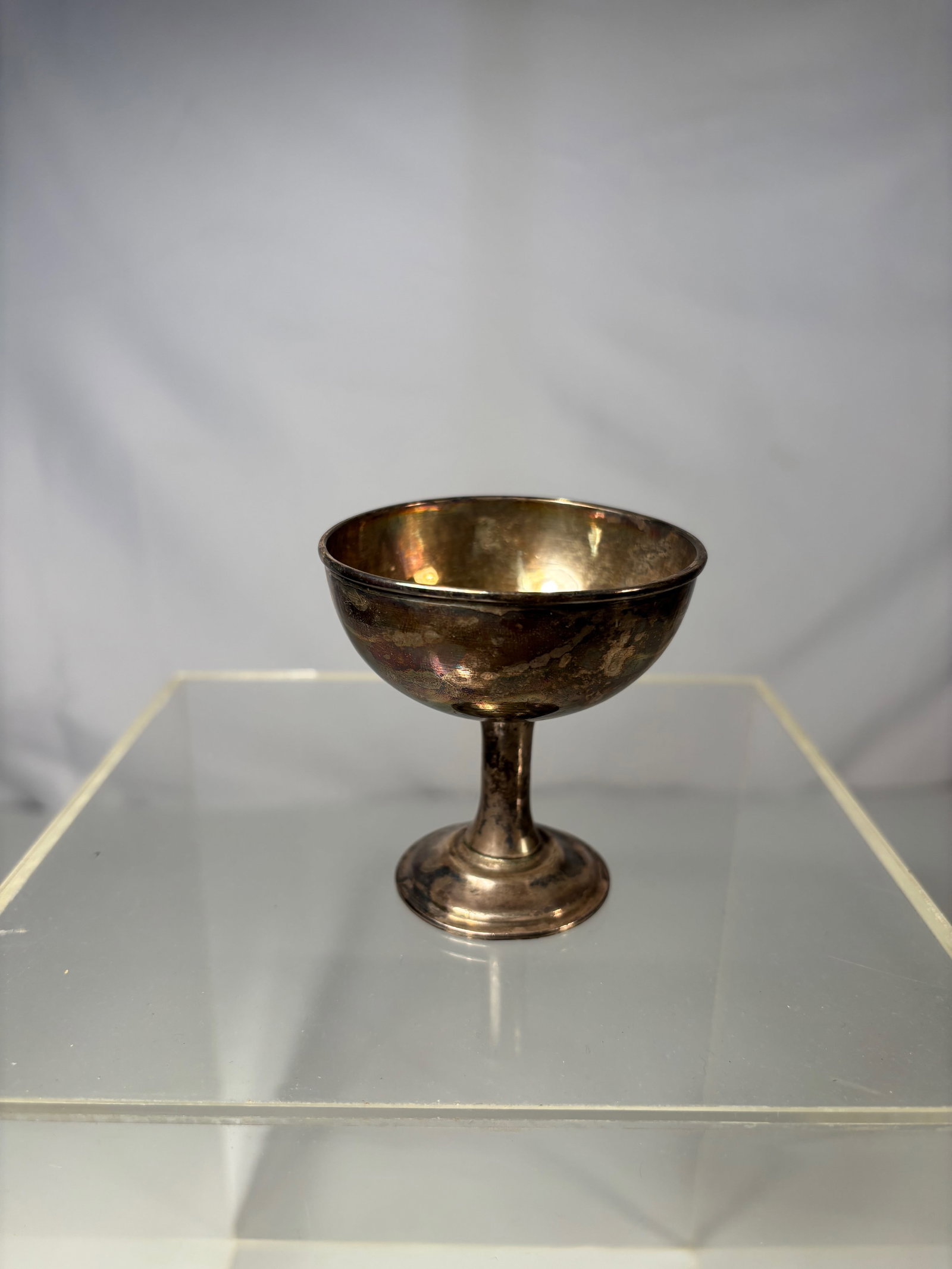 A Chinese Sterling Silver Goblet, Marked" shang zu yin": Early 20th Century, A petite, stemmed goblet featuring a rounded bowl and flared foot, finished with a warm, aged patina. The underside bears stamped hallmarks"SHANG ZU YIN" . ?Dimensions?Height: 2.65