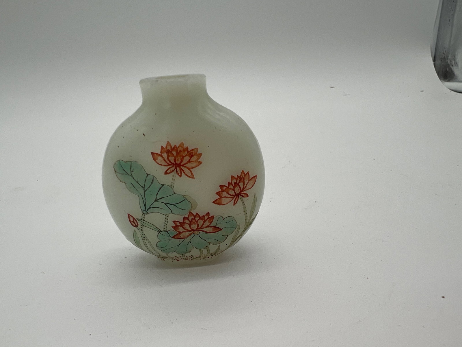 A GUYUE XUAN ENAMELED WHITE GLASS SNUFF BOTTLE: IMPERIAL, YANGZHOU, 1770-1799; It decorated with a painted design featuring lotus flowers and lily pads. The base has a three-character Guyue Xuan mark in iron red.Dimensions?2 in. (5.5 cm.) high, .