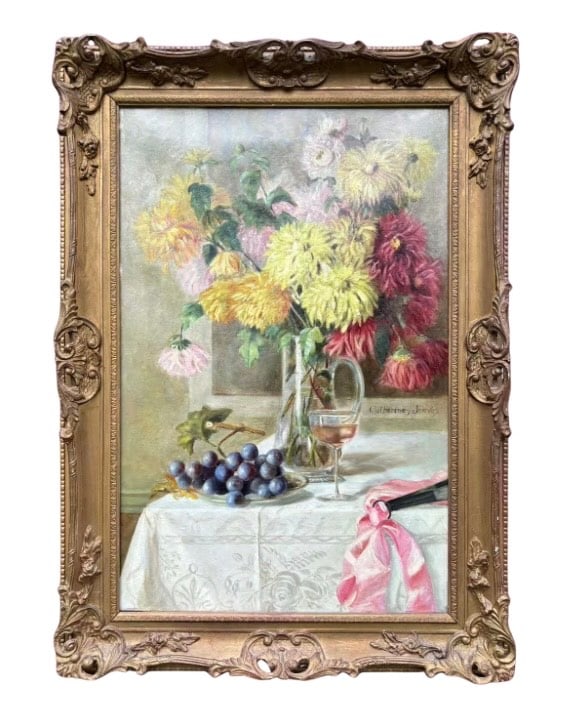 “Pink Satin Bow" signed ‘Catherine Jeeves’, ca. 1889, England: This elegant still life oil painting depicts a richly composed tabletop scene featuring a bouquet of chrysanthemums, a wine glass, grapes, and a pink satin bow—the latter providing both the title an