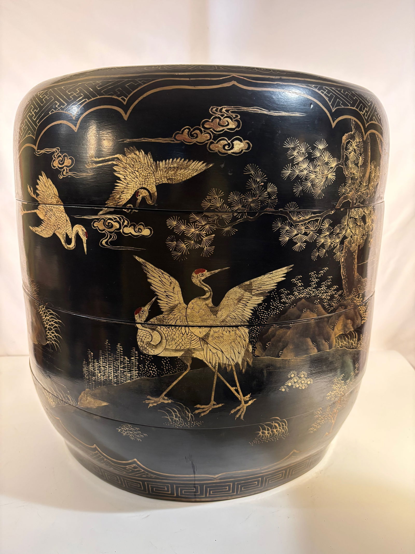 A Super Large Japanese Lacquer Hibachi with Gilt Decoration of Cranes and Pines, Meiji Period: Meiji Period (1868–1912); A Japanese black lacquer hibachi, late 19th to early 20th century, of rounded form decorated in gilt with cranes in flight and standing among pine trees, symbols of