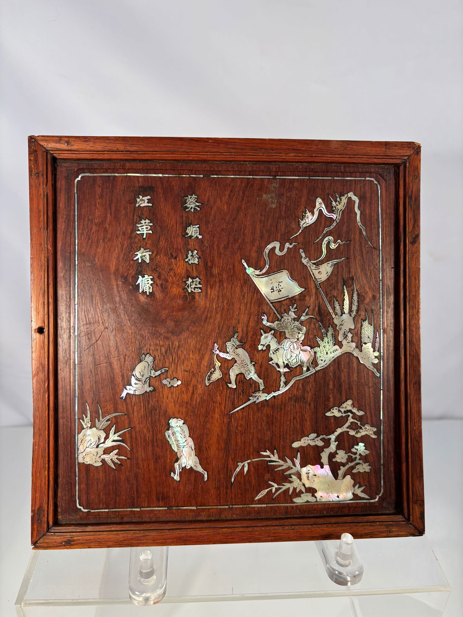 A Chinese Huanghuali and Mother-of-Pearl Inlaid Panel: Late 19th Century; A rectangular huanghuali wood panel inlaid with mother-of-pearl, depicting a procession of warriors with banners in a mountainous setting with pine and bamboo, together with a four-