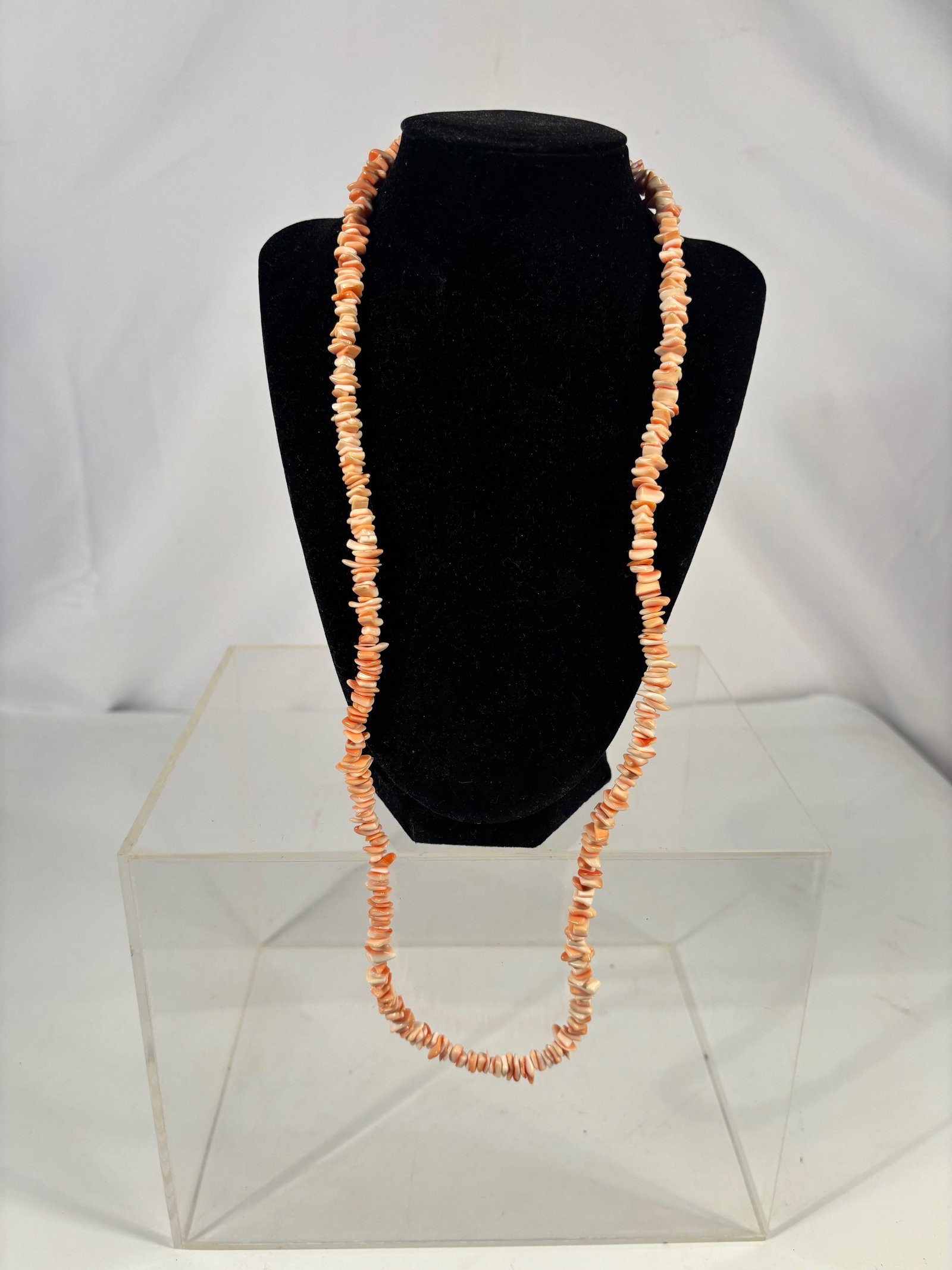A Mediterranean Coral Chip Necklace 30 inches: An antique necklace composed of natural Mediterranean coral chips, exhibiting soft peach to pale salmon tones with natural color variation. The irregular coral chips are hand-drilled and strung in a s