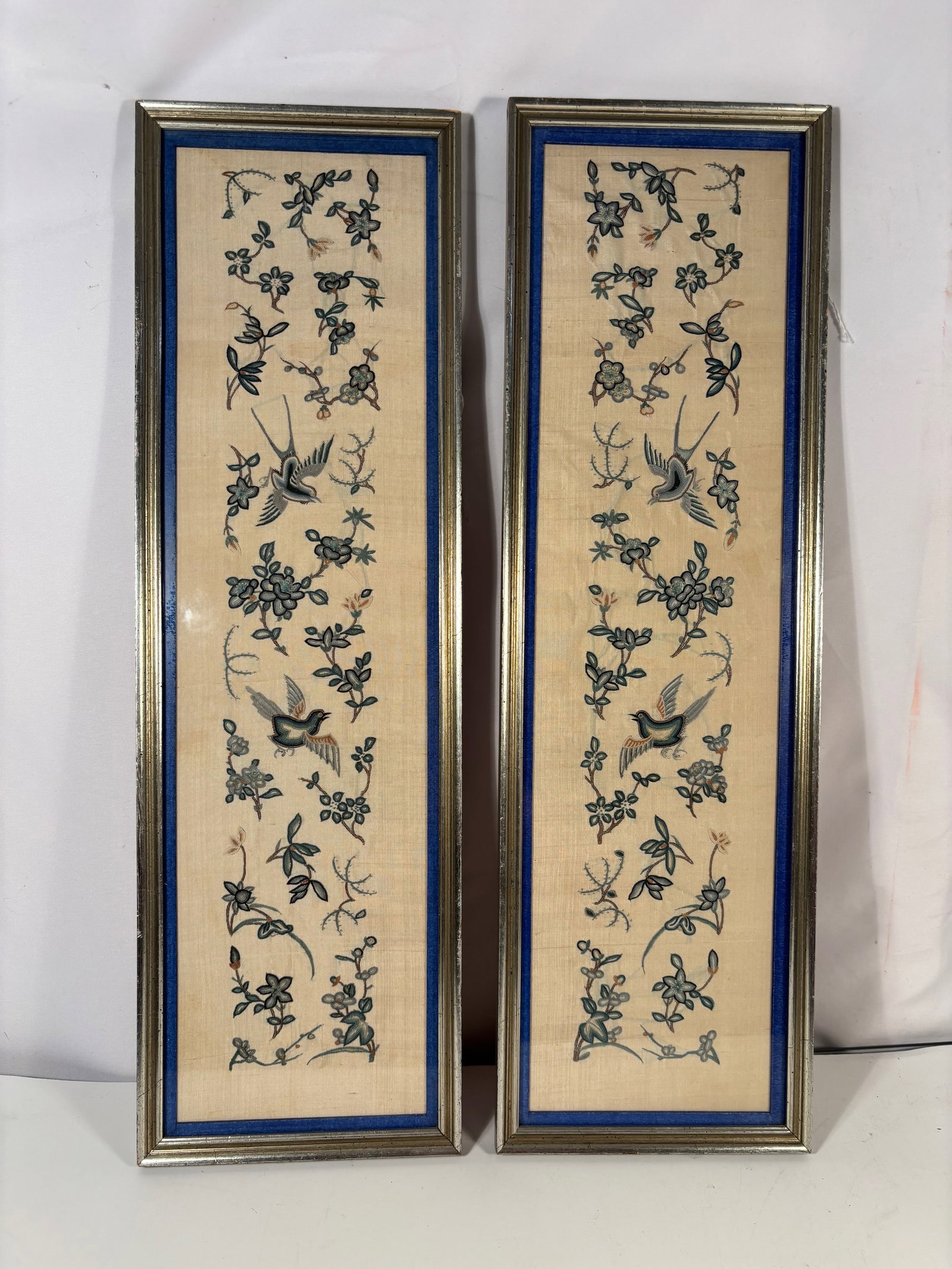 Pair of Chinese Framed Silk Embroidery Panels with Birds and Floral Motifs: 19th Century, Pair of Chinese silk embroidery panels depicting birds among floral vine motifs, mounted and framed under glass. Each height: 22 inches; Each Width: 7 inches.