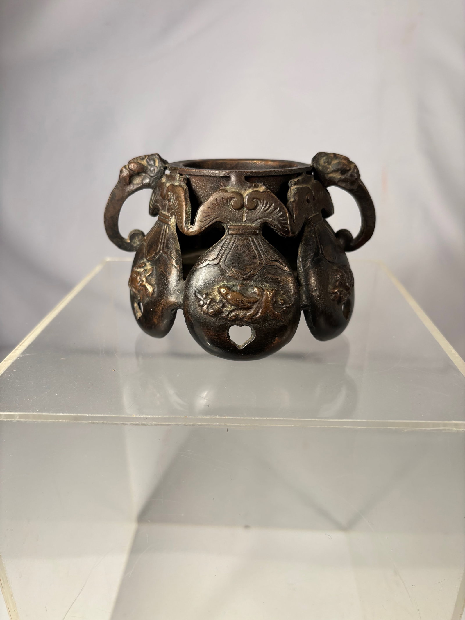 A Japanese Bronze Censer, Xuande Mark, Marked Japan: 19th Century ; A Japanese bronze censer with relief decoration and loop handles. The base bears a Xuande mark and is additionally stamped “Japan,”. Height: 3 inches; Diameter: 3.75 inches.