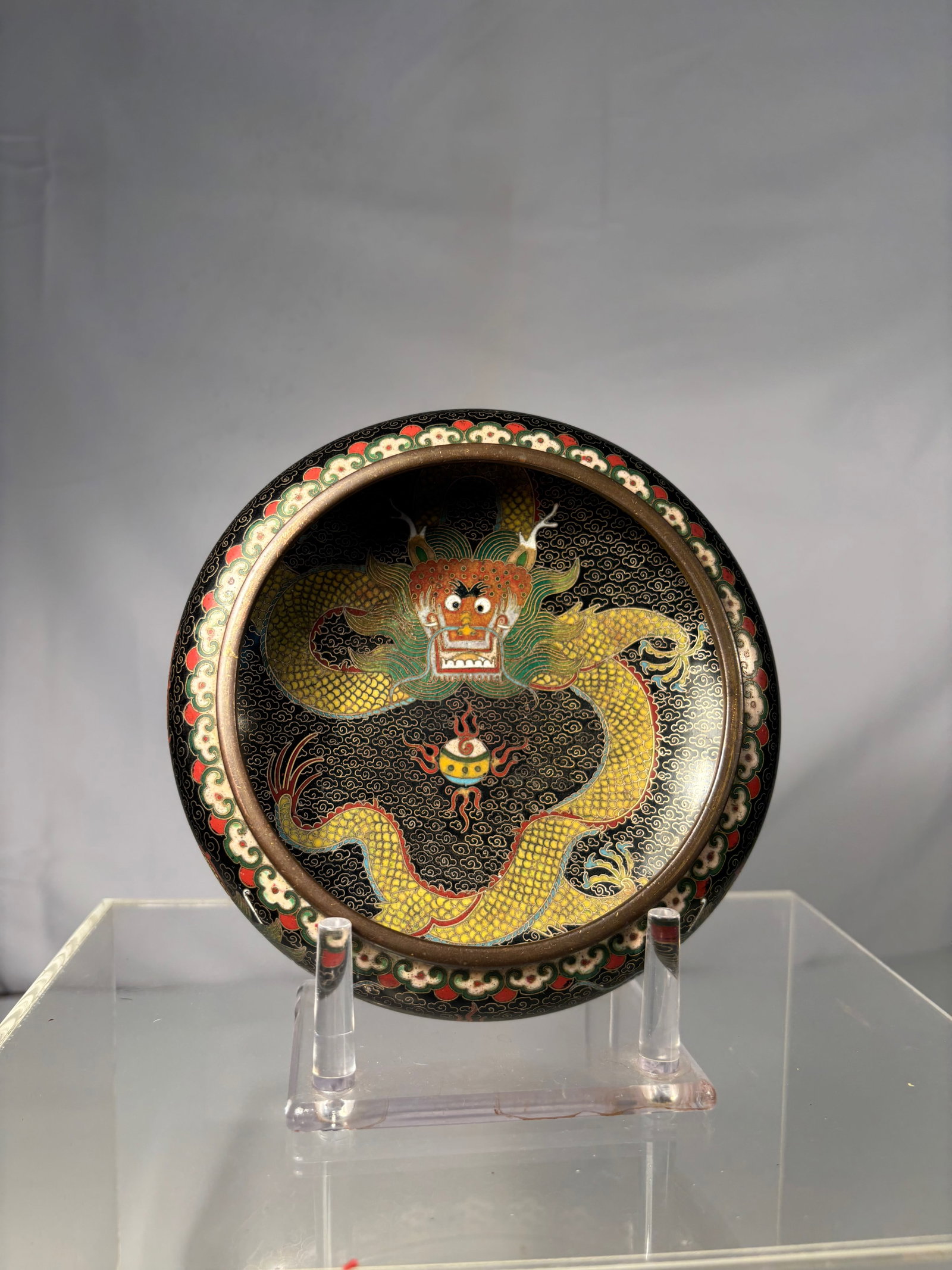 A Chinese Cloisonné Enamel Bowl with Five-Clawed Dragon on Black Ground MARKED"LAO TIAN LI": Qing dynasty(1644-1912); Chinese cloisonné enamel bowl, Marked Lao Tian Li (????), the interior finely decorated with a five-clawed imperial dragon in vivid yellow, green, and red enamels pursuing a