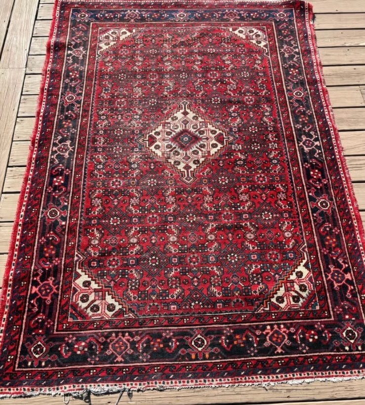Early-to- mid 20th century persian Hand knotted 100% wood rug: Diamond medallion on a richly patterned red field, filled with small geometric rosettes and stylized floral forms.Deep indigo/navy borders with traditional corner motifs.The back view shows a tight, d