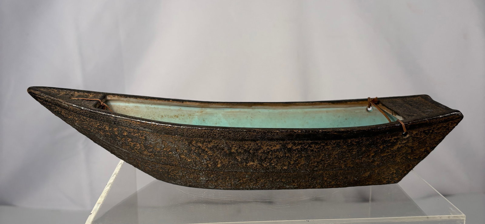 Japanese Boat-Form Ikebana Vessel with Iron-Like Textured Exterior and Turquoise Oribe-Style: A Japanese Meiji Period boat-form ikebana vessel featuring an iron-like textured exterior with a dark, rustic finish and naturally aged surface. The long, slender hull tapers to a pointed bow and a sq