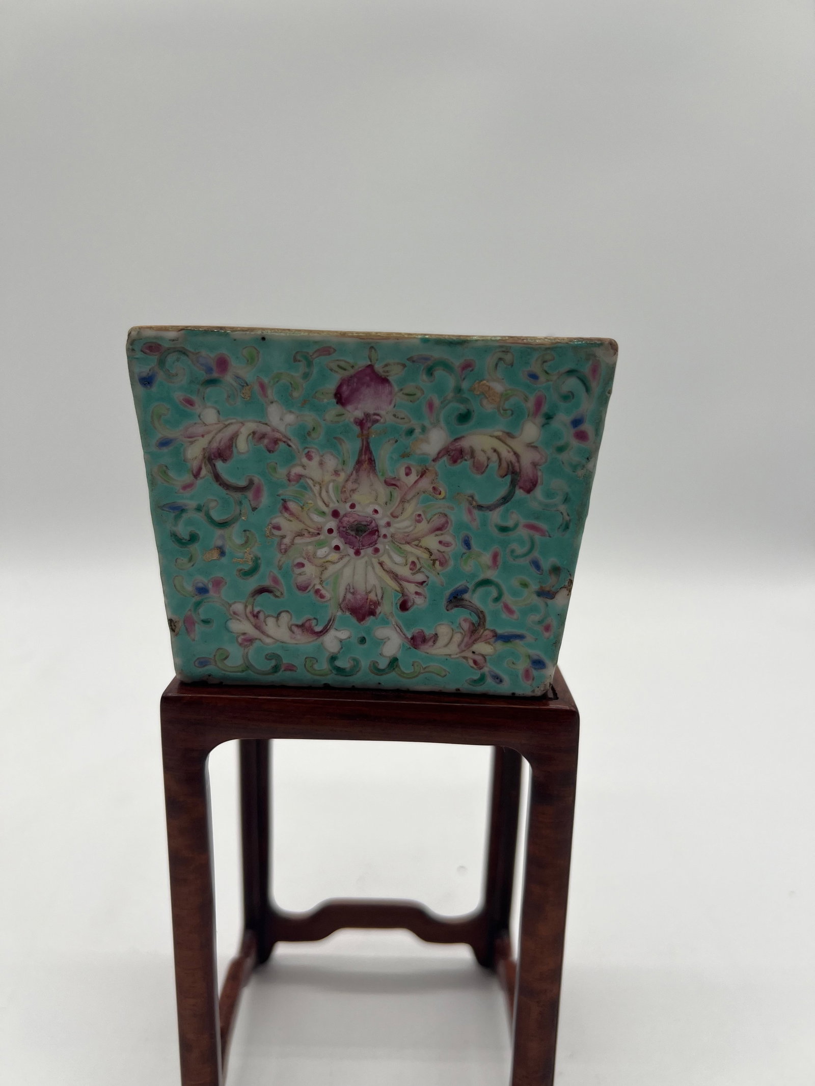 A Chinese turquoise glazed square porcelain water pot with TongZhi Mark in red iron: Late 19th century; The turquoise background features a scrolling floral pattern with pink, white, and green accents, consistent with famille rose porcelain. The textured, raised enamel detailing adds