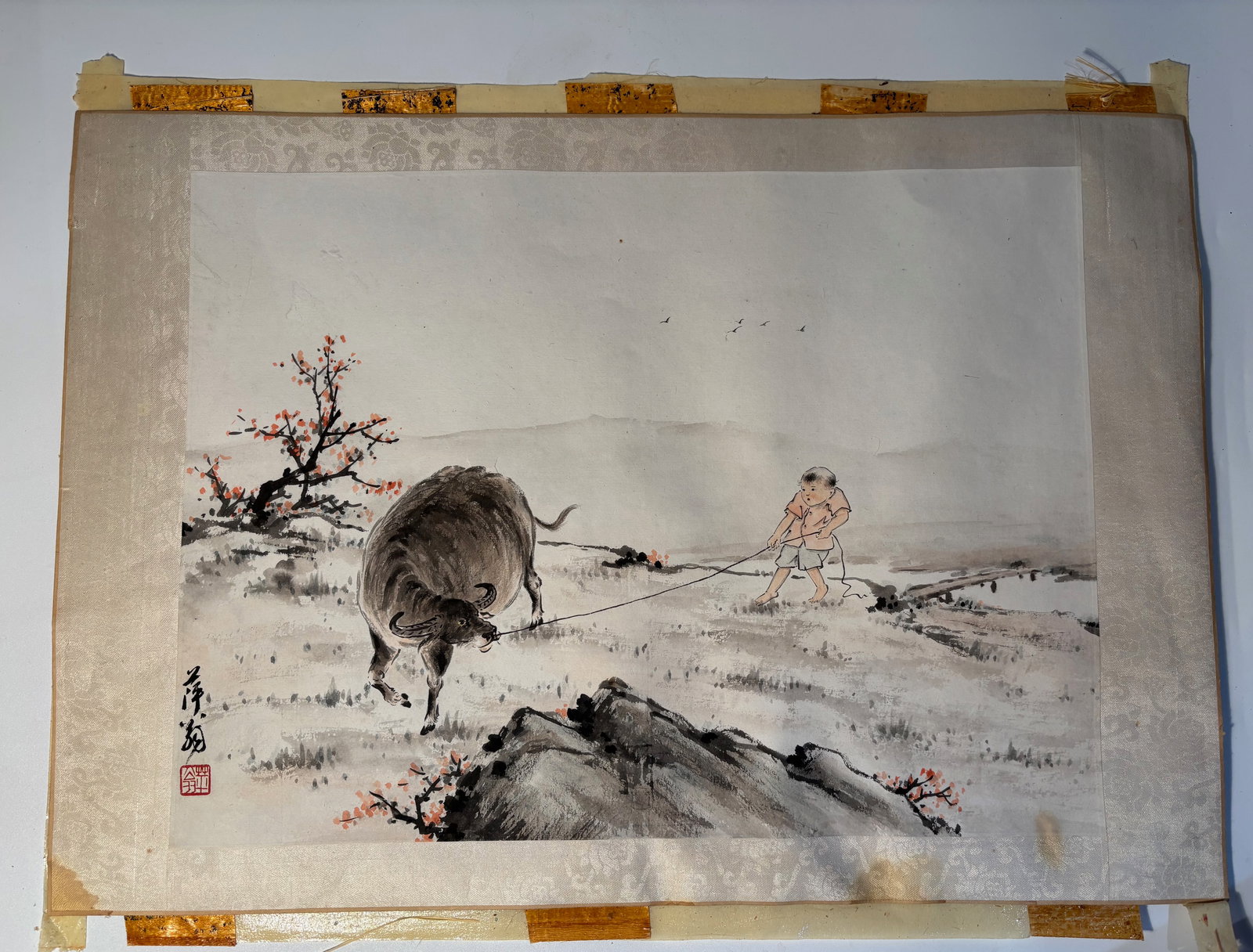A Chinese water colour painting by QI BAISHI(1864-1957) Signed PING WEN: This is a traditional Chinese ink painting featuring a child pulling a water buffalo, a classic theme in Chinese art symbolizing harmony with nature and rural life. The style and composition resemble