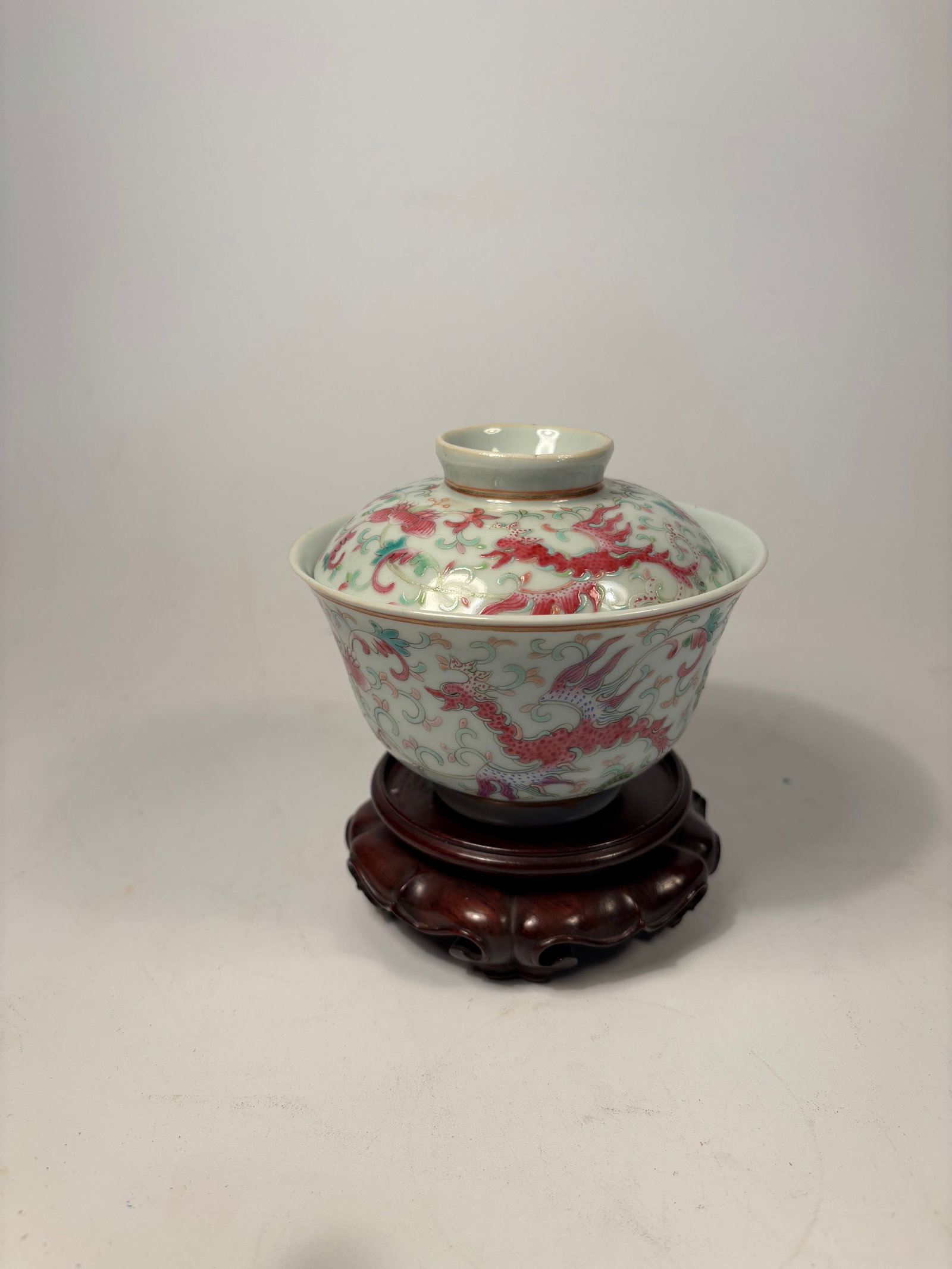 A Chinese Famille Rose Porcelain Dragon Bowl with Cover with "QIANLONG" mark: Qing dynasty(1644-1912); Finely enamelled in the famille rose palette, the bowl and its matching domed cover are both decorated with five-clawed imperial dragons in vibrant iron-red, emerald green, an