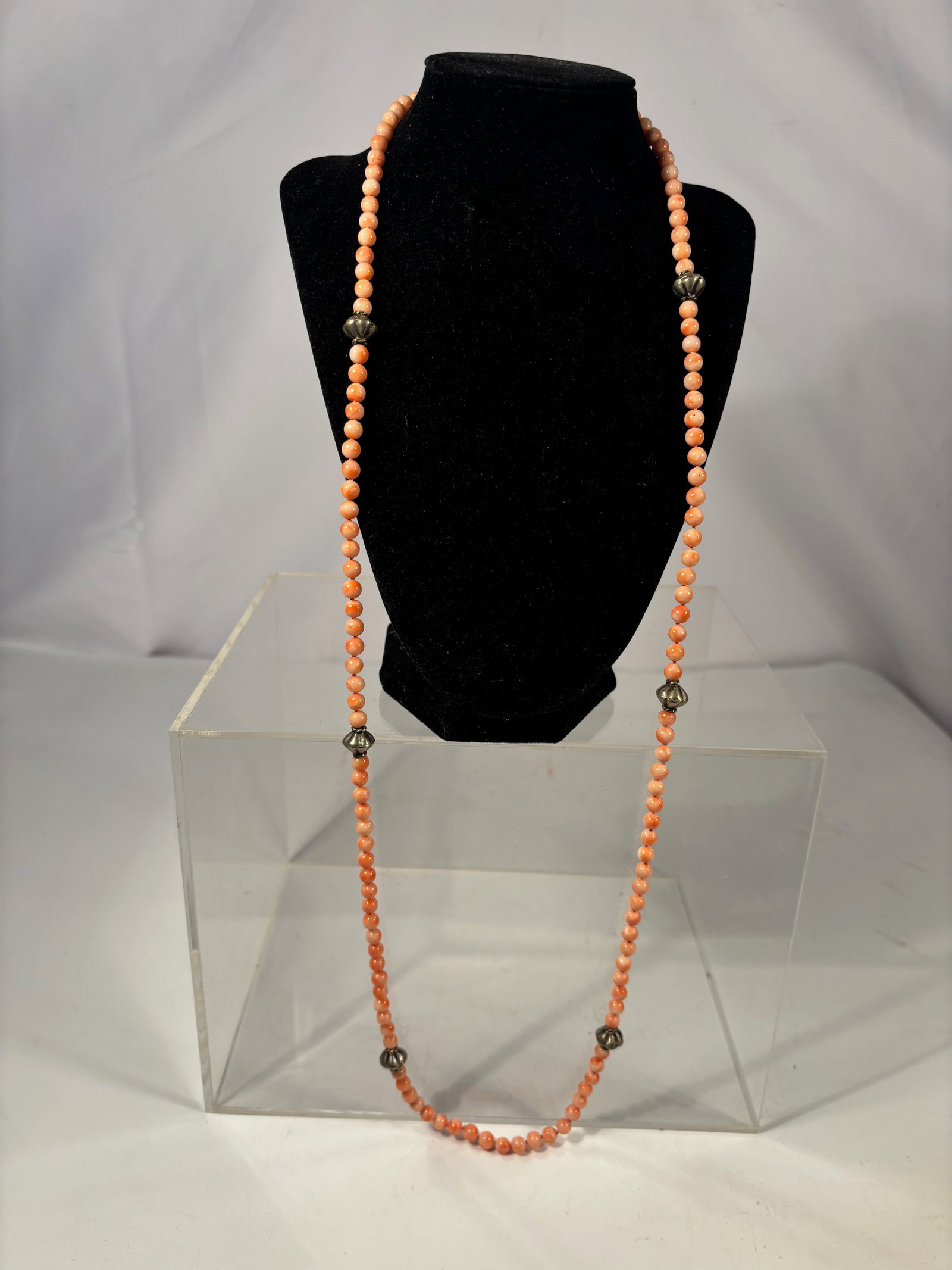 Vintage Coral Bead Necklace with Silver-Tone Spacers, 37 Inches: A vintage necklace composed of small round coral beads, measuring approximately 37 inches in length. The strand is accented with silver-tone metal spacer beads (material untested). The coral beads dis