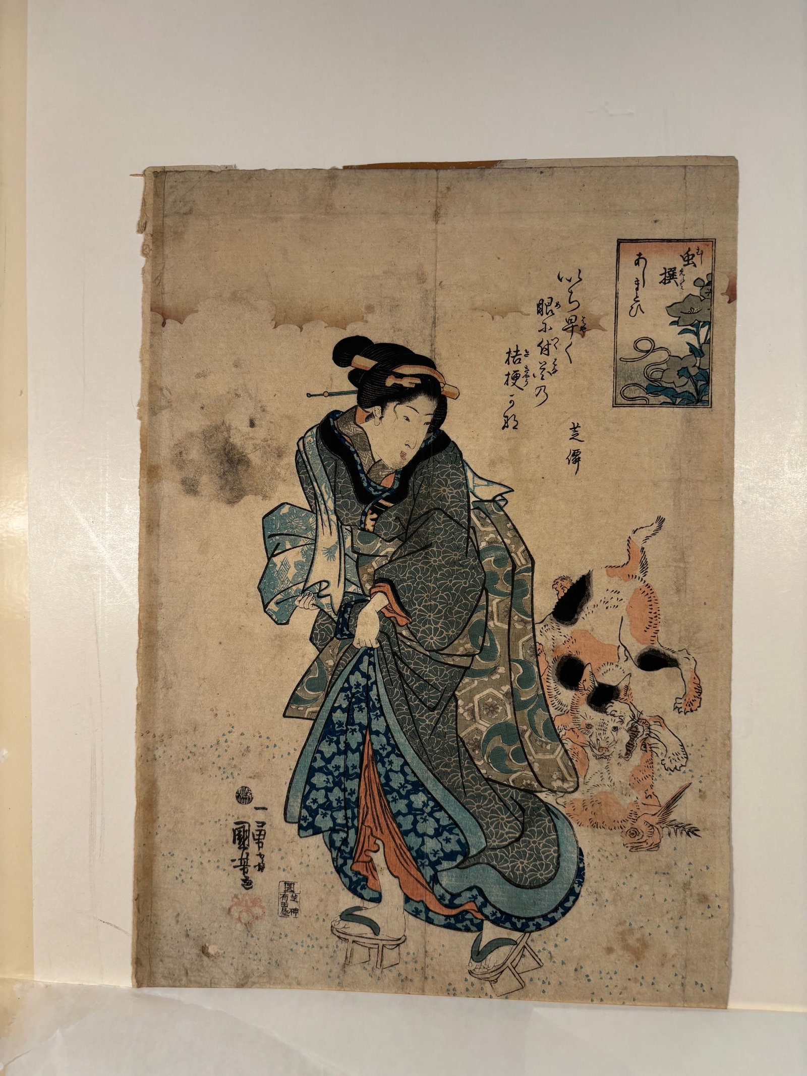 Utagawa Kuniyoshi (1797–1861) Beauty with a Dog, from a series with Poetic Cartouches, Woodblock: Date: Edo period, ca. 1840s–1850s; A bijin-ga print by Kuniyoshi depicting a standing beauty in layered kimono patterned with chrysanthemums and arabesques, holding her robe while a small spotted do