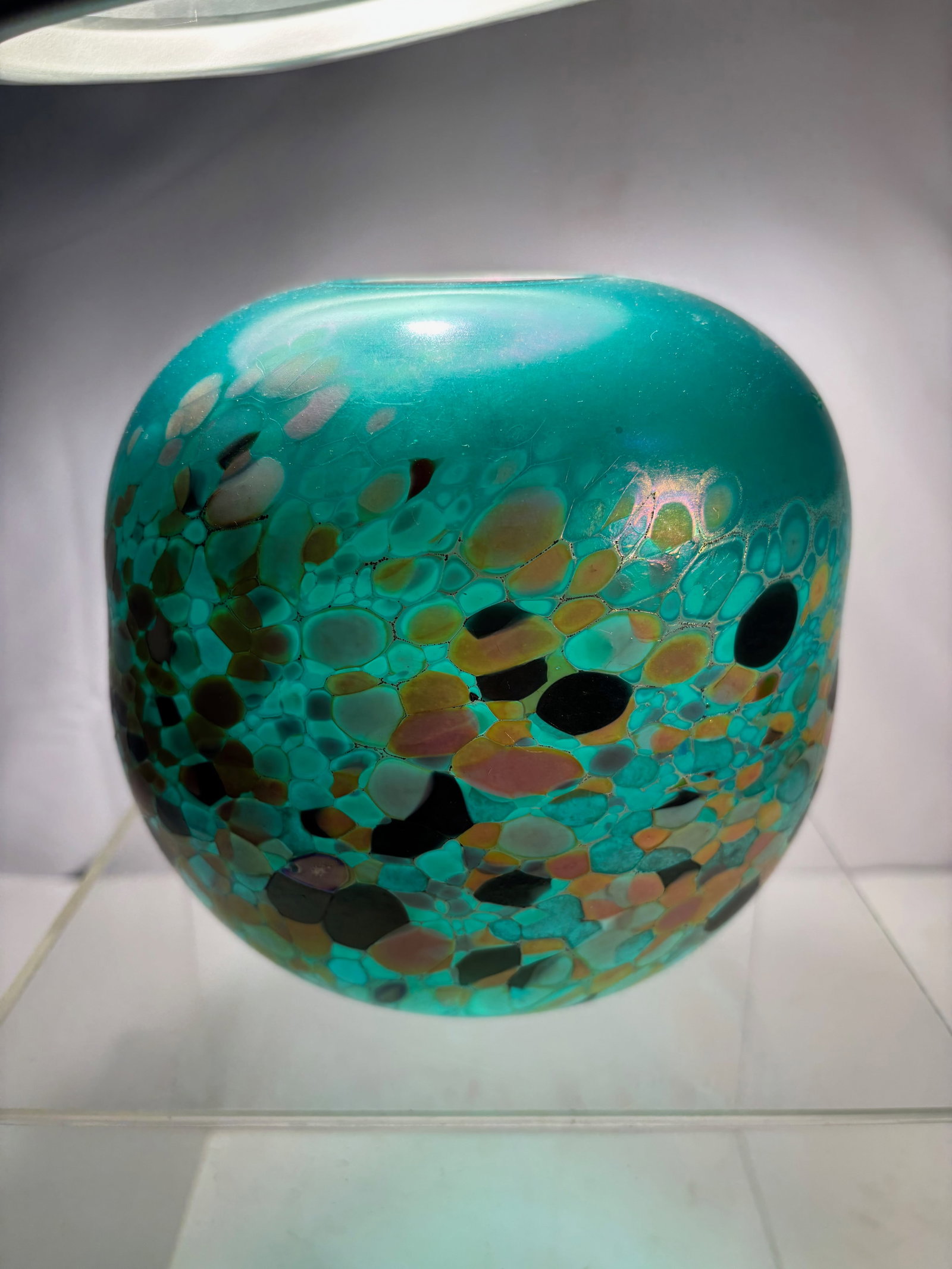 A Signed Studio Art Glass Bowl, 1992: Studio art glass bowl of rounded form, executed in translucent teal glass with multicolor mottled inclusions creating a cellular, organic pattern throughout the body. The surface exhibits subtle iride