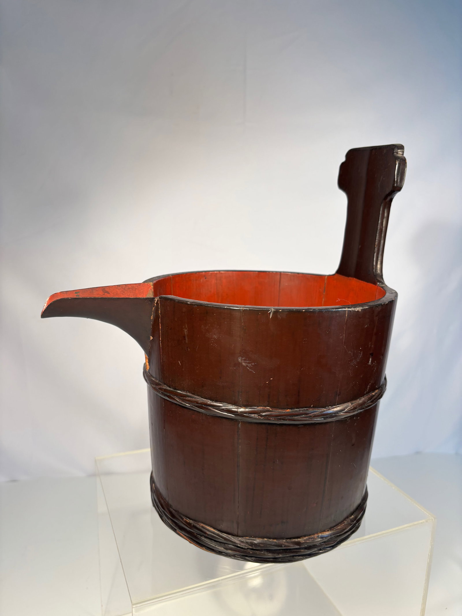 A Japanese Lacquered Bamboo Pouring Vessel with Inscription: Meiji Period (1868–1912); Of traditional coopered form, constructed from vertical bamboo staves bound with rattan strips, the cylindrical body fitted with a projecting spout and upright handle. The