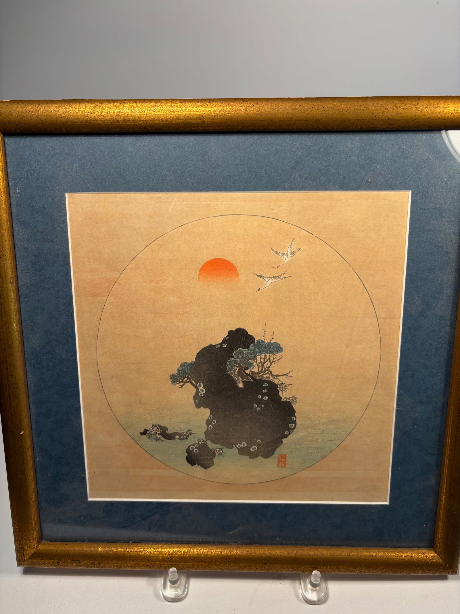 A Japanese Nihonga-Style Circle Painting, “Rising Sun with Cranes and Pine,: Japanese School, circa 1900; A finely painted circular-format composition (possibly a uchiwa-e or fan painting), depicting two flying cranes before a rising sun over waves and fantastical