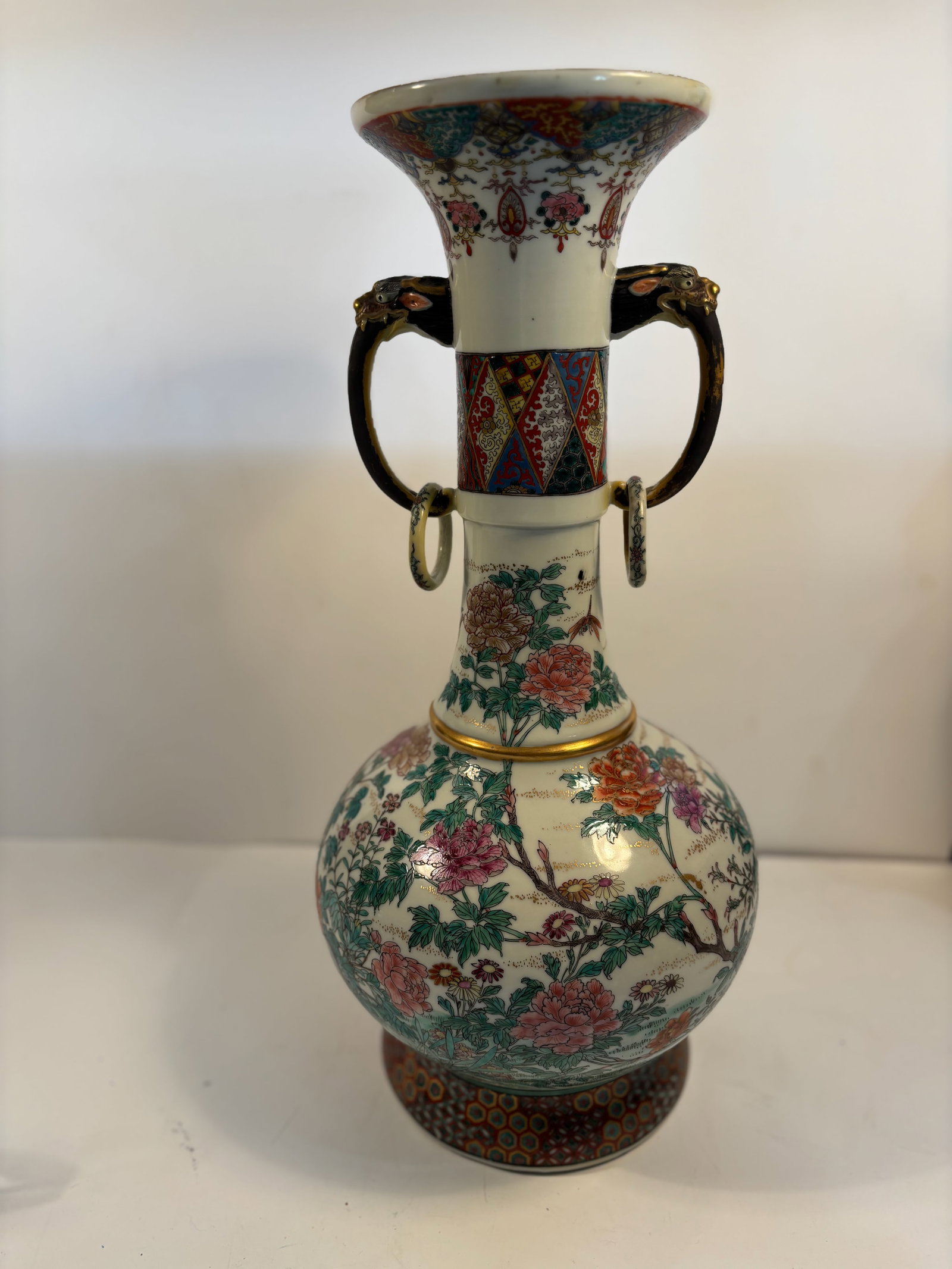 A Large Japanese Satsuma-Style porcelain Vase with two handles and rings: late Meiji to Taish? period (circa 1890–1920s);Delicate overglaze enamel floral decoration with fine gold detailing. Dimensions?Height: 19.5 inches; Width: 9.5 inches.
