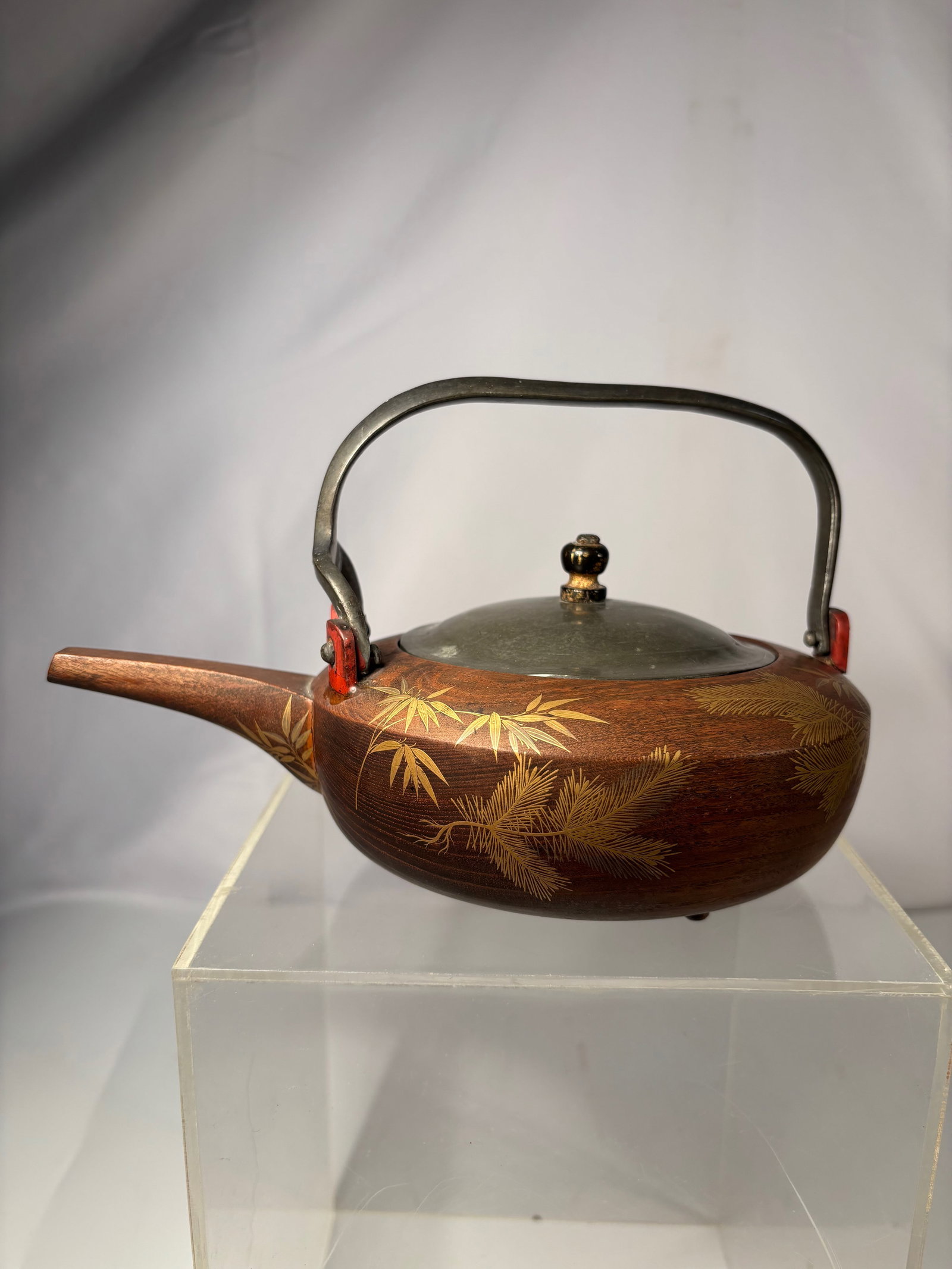 A Japanese Lacquered Wooden Teapot with Maki-e Pine & Bamboo Decoration (Edo–Meiji Period ,: A Japanese wooden teapot of yakan form, dating to the late Edo to early Meiji period (circa mid–19th century). The body is lathe-turned from hardwood and finished with a rich vermillion lacquered in