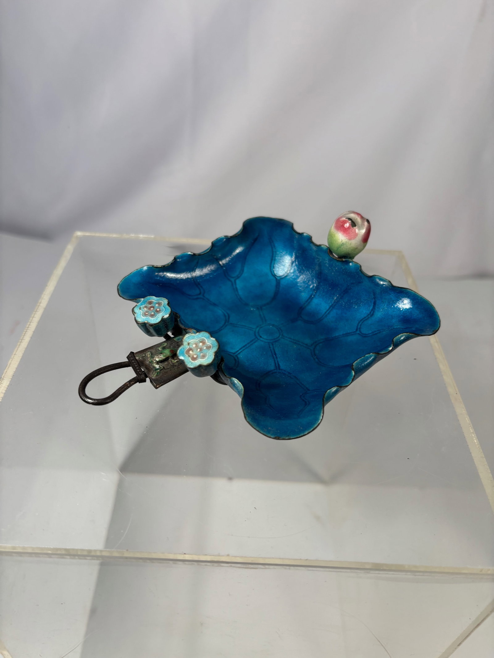 A Chinese Cloisonné Enamel Lotus Leaf Form Tray with Silver-Tone Metal Mounts,: Qing dynasty(1644-1912); Chinese cloisonné enamel tray modeled in the form of a stylized lotus leaf, decorated in vibrant blue enamels with veined leaf detailing. The piece is accented with applied f