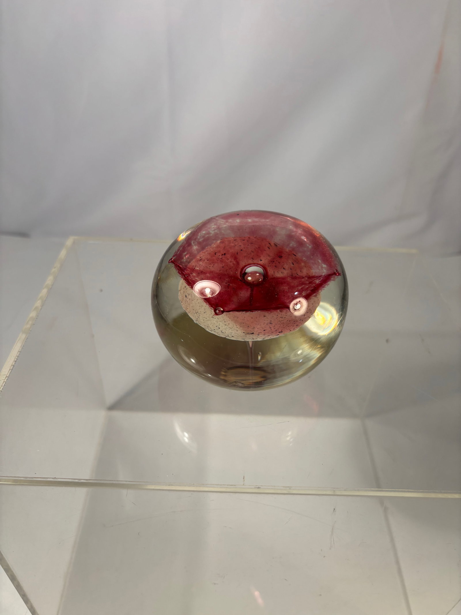 Terry Bloodworth S.D.C. Studio Art Glass Paperweight Pink Flower Splash: Terry Bloodworth (American, 20th century) S.D.C. Studio Art Glass Paperweight. The spherical form encasing a suspended pink flower splash design, centered with a metallic orb and vertical clear stem e