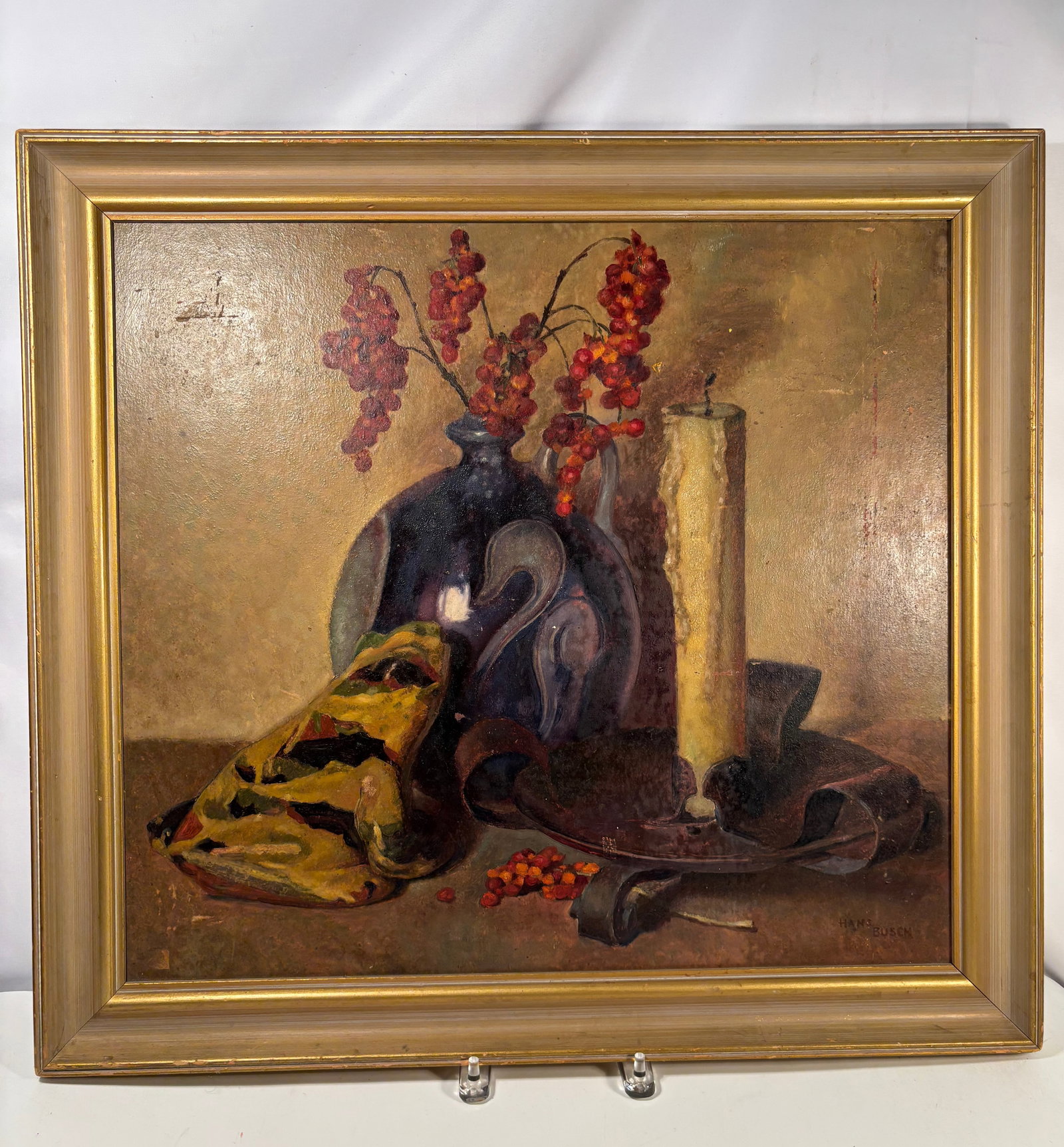 Hans Busch (American, 1884–1954) Oil on Canvas Still Life with Vase and Berries: Oil on canvas depicting a dark ceramic vase with cascading red berries, a standing candle, and draped fabric arranged upon a tabletop. Executed in a warm tonal palette with confident academic brushwor
