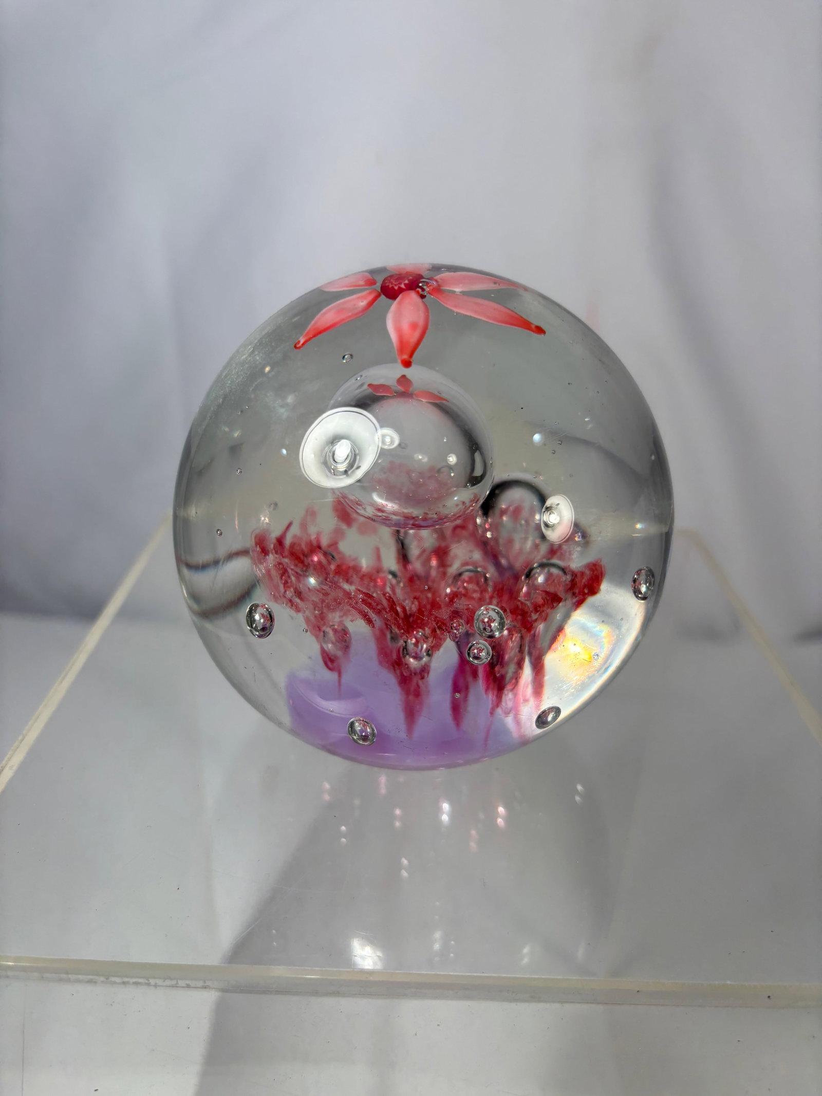 Studio Art Glass Paperweight w/ Red Floral Inclusion & Controlled Bubbles: Hand-blown studio art glass paperweight featuring a clear orb form with vivid red floral-style inclusions and suspended bubble elements. The interior displays a stylized red blossom at the top, with c