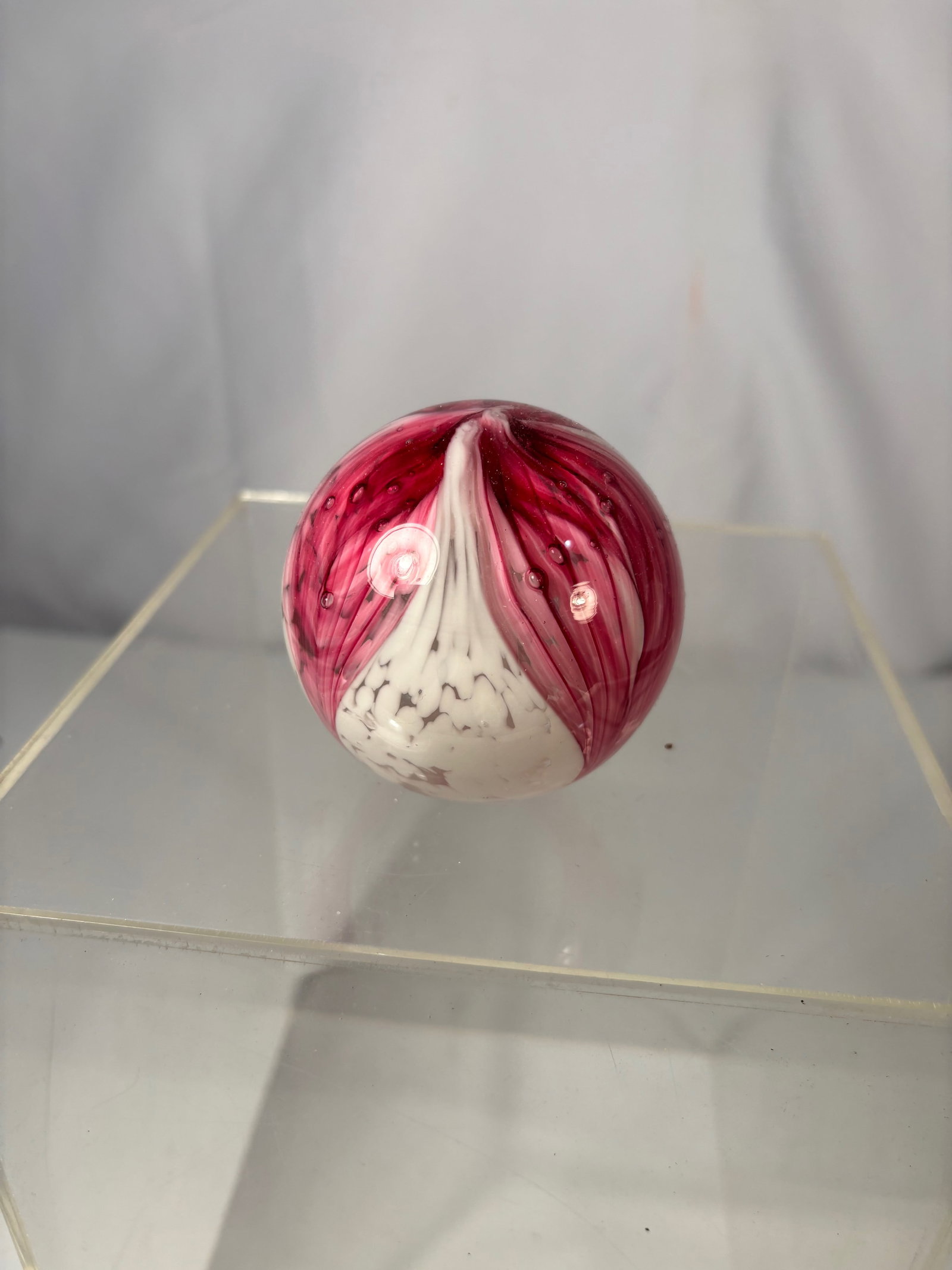 Peacock Glass Works Art Glass Paperweight, Red & White Floral Design, Elwood Indiana: This art glass paperweight is produced by Peacock Glass Works of Elwood, Indiana, and is signed on the base. The piece features a clear glass body with layered red and white floral-style inclusions, c