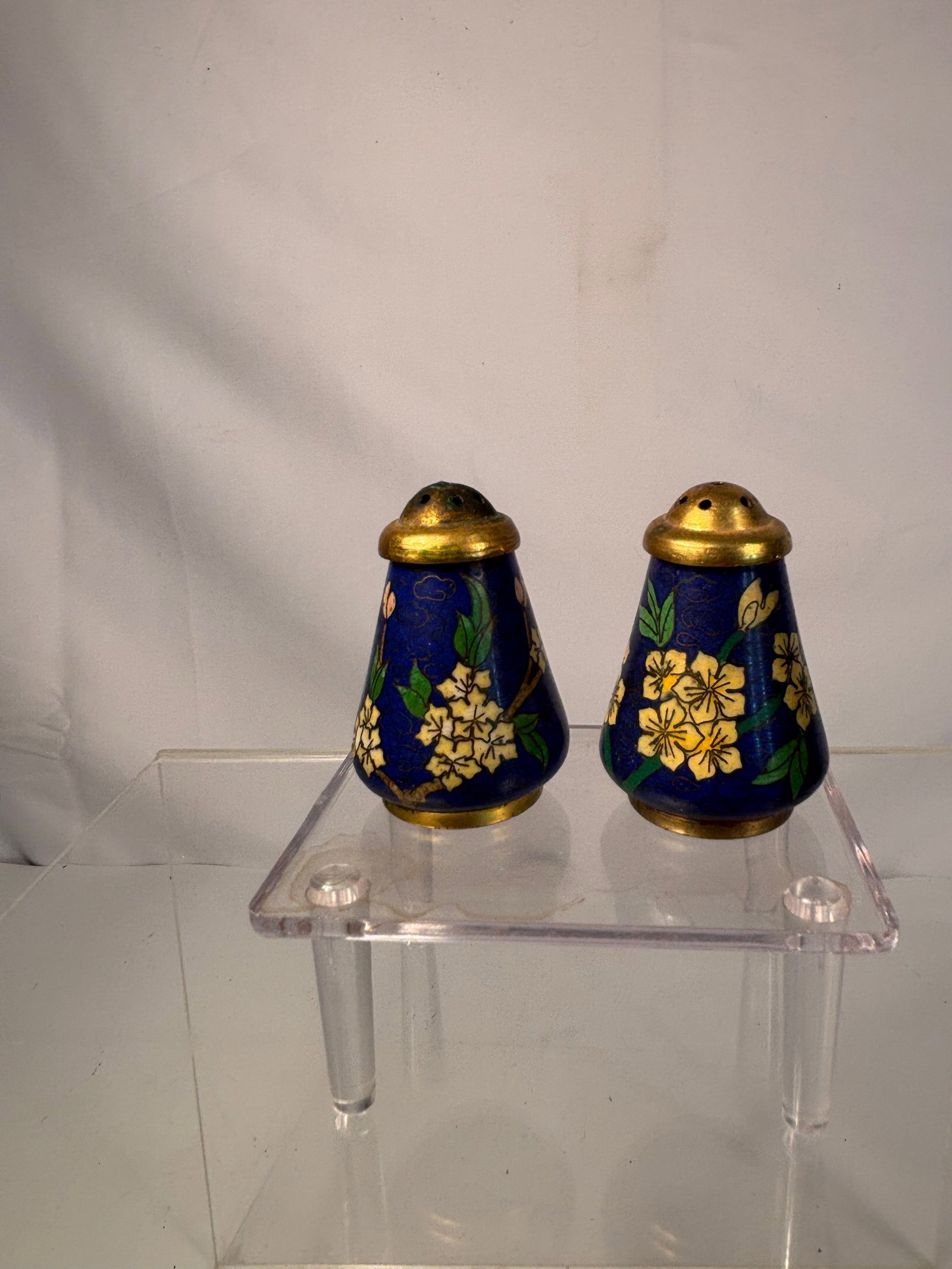 Pair of heavy Chinese Cloisonné Enamel Salt and Pepper Shakers, 19th Century: A charming pair of miniature Chinese cloisonné enamel shakers, each decorated with vivid yellow floral motifs and green leaves on a rich cobalt blue ground. Fitted with pierced gilt-brass tops and tu