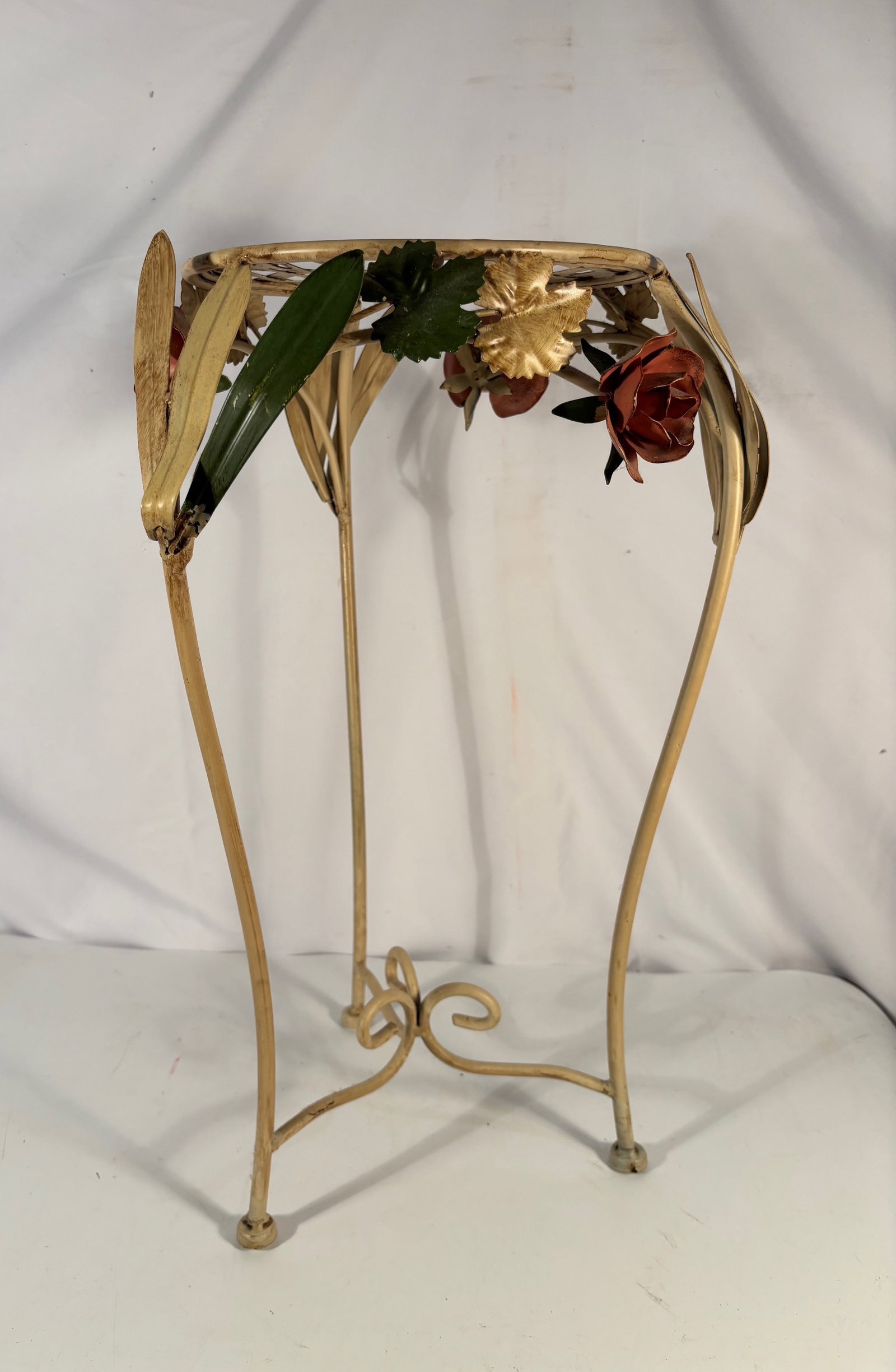 A Vintage Tole Metal Floral Plant Stand: Vintage decorative metal plant stand featuring gilt metal construction with applied floral decorations including roses and leaves. Likely mid-20th century, possibly Italian toleware style. Height: 22 