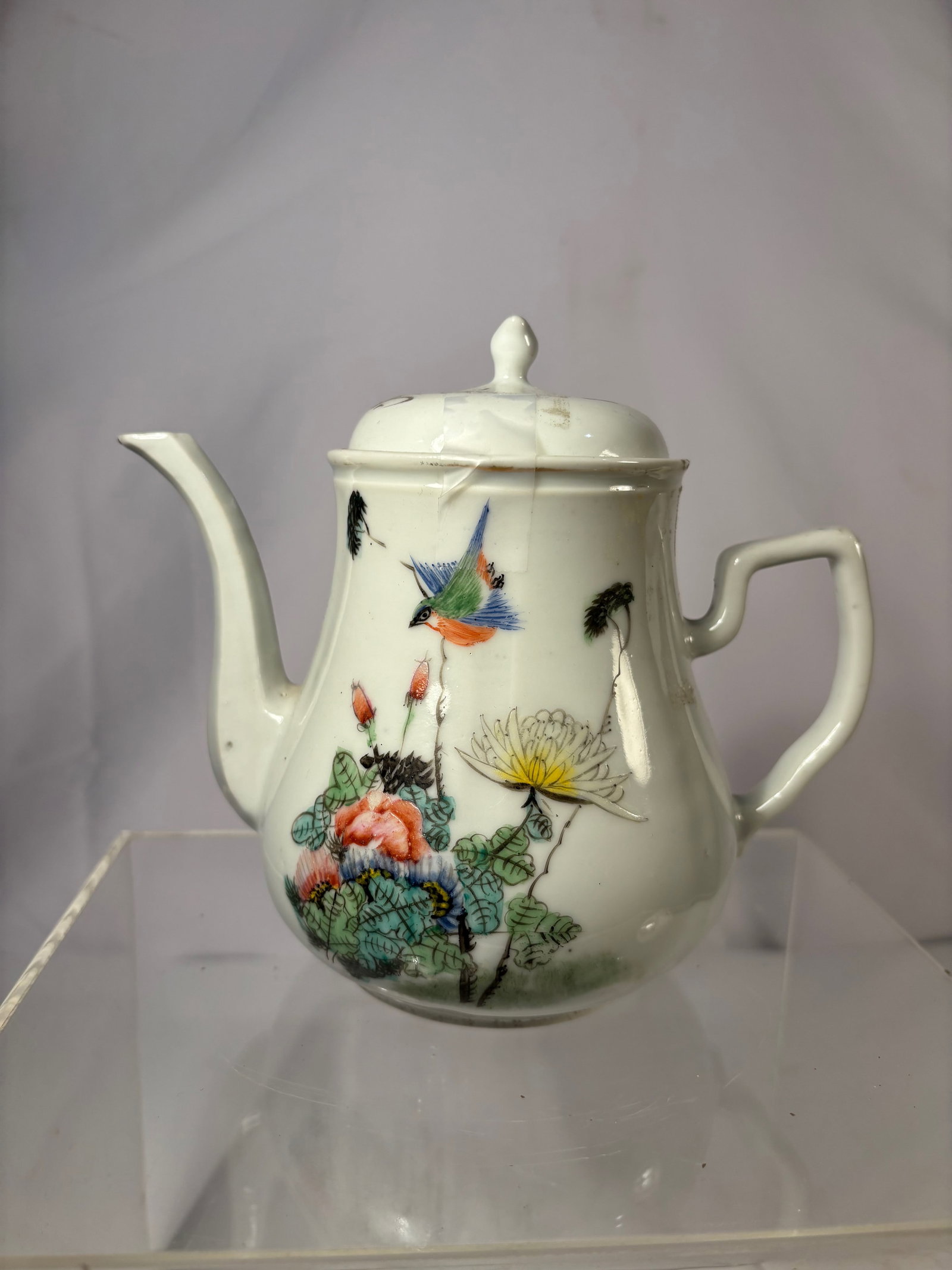 A Chinese Famille-Rose Porcelain Teapot with Calligraphy: Republic Period (1912–1940); A finely painted Chinese porcelain teapot, the body delicately enameled with a scene of birds in flight amid blooming peonies and lotus, executed in soft famille-rose en