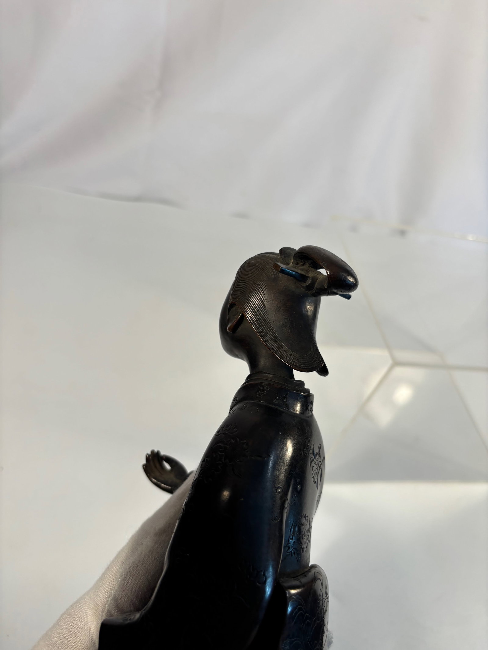 A Japanese-Style Bronze Figure of a Young Woman in Kimono, Meiji period: Meiji period (1868-1912); A fine Meiji period Japanese bronze figure depicting a young woman dressed in a traditional kimono, standing gracefully with her head slightly tilted and holding her garment 