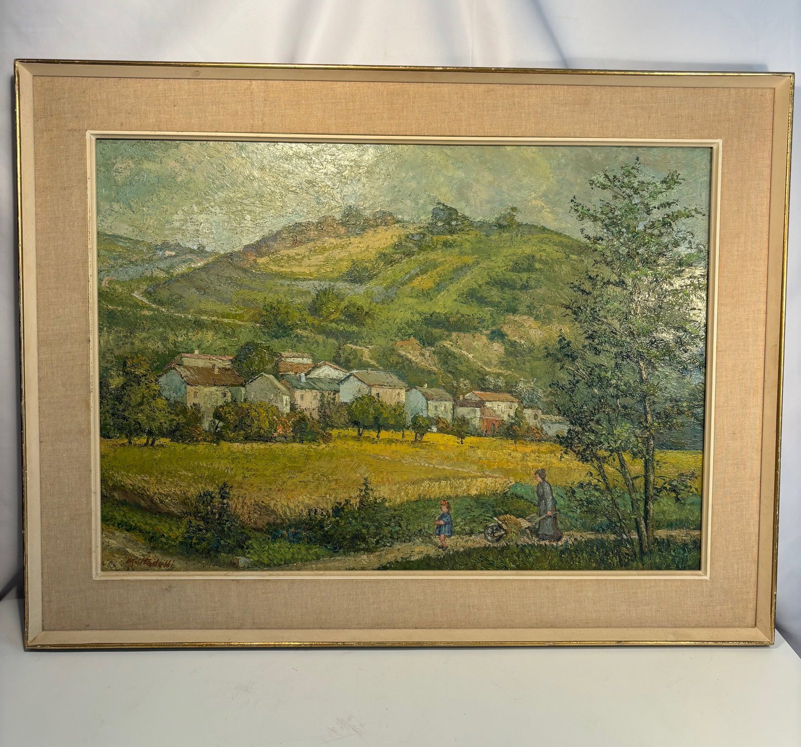 Giuseppe Mottaedelli (Italian, mid-20th century) , Village in the Hills, Oil on canvas, signed on: A vibrant Italian countryside scene depicting a cluster of houses nestled among green rolling hills under a luminous sky. Executed with thick impasto and confident brushwork, the painting captures the