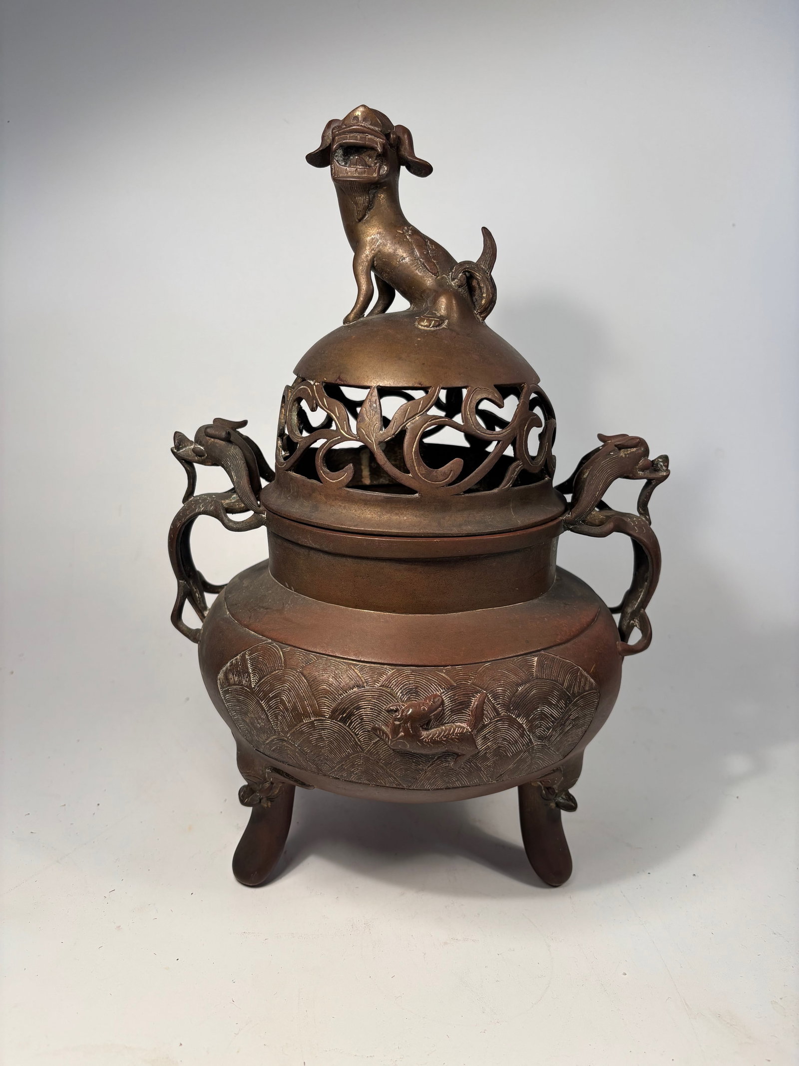 A Chinese gilted Bronze Tripod Censer with Lion-Dog Finial with sign "DA MING XUAN DE YAN ZHI": Qing dynasty(1644-1912); Of baluster form raised on three curved legs, the censer features a pierced domed cover surmounted by a seated lion-dog (Bixie or Buddhist lion) with exaggerated features and 