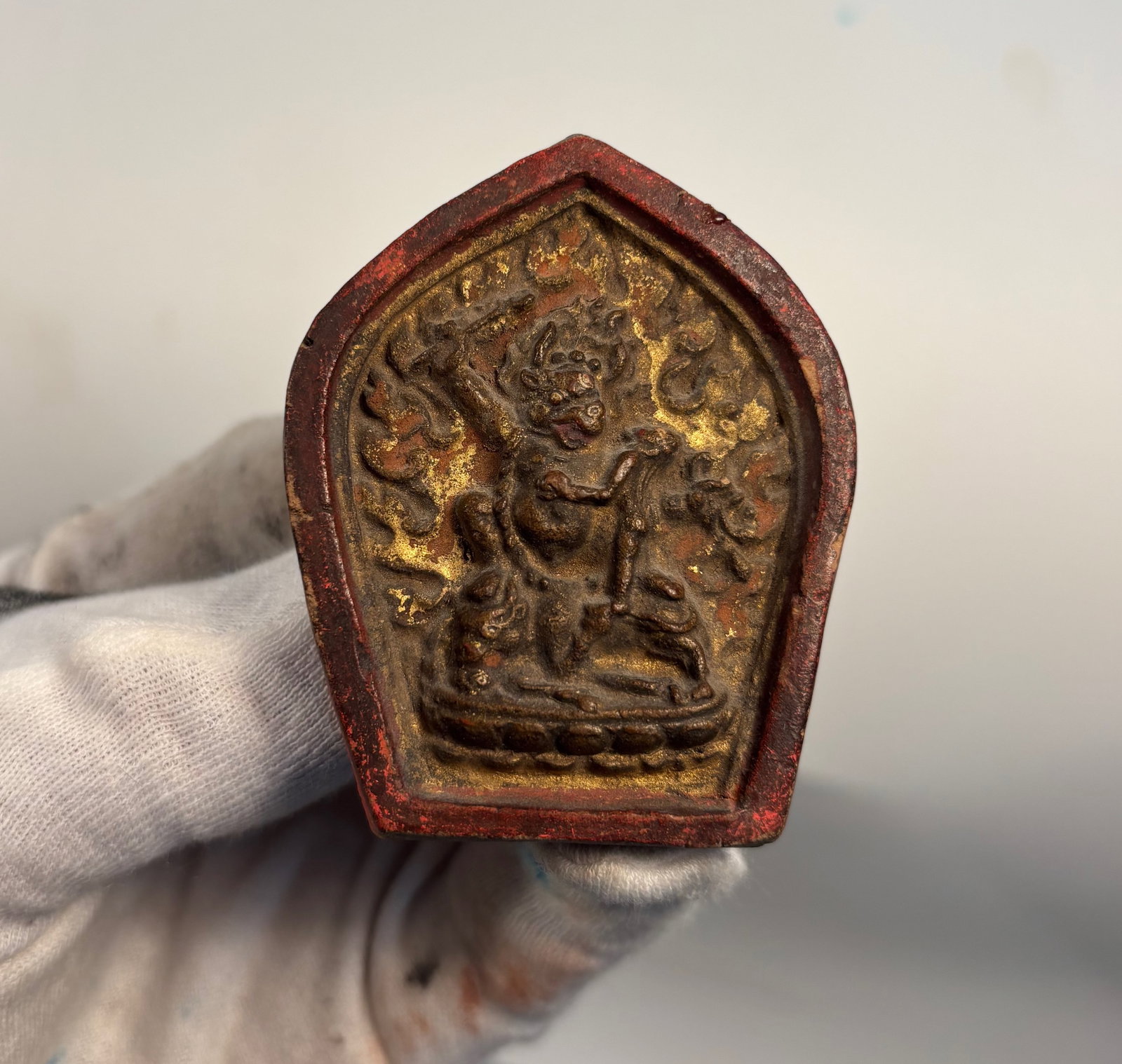 Tibetan terracotta tsa-tsa plaque: 19th century ,A Tibetan tsa-tsa plaque molded in relief, depicting a wrathful deity (likely Vajrapani or Mahakala) encircled by flames, symbolizing spiritual protection and purification. Created from 