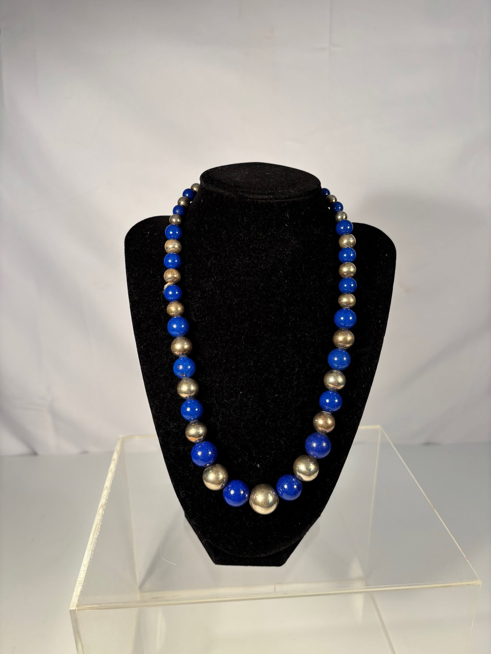 Vintage Lapis Lazuli and silver Bead Necklace, 19 inches: A vintage necklace featuring alternating polished lapis lazuli beads and silver beads, strung in a bold and elegant design. The lapis stones exhibit a rich deep blue color, complemented by the cool sh