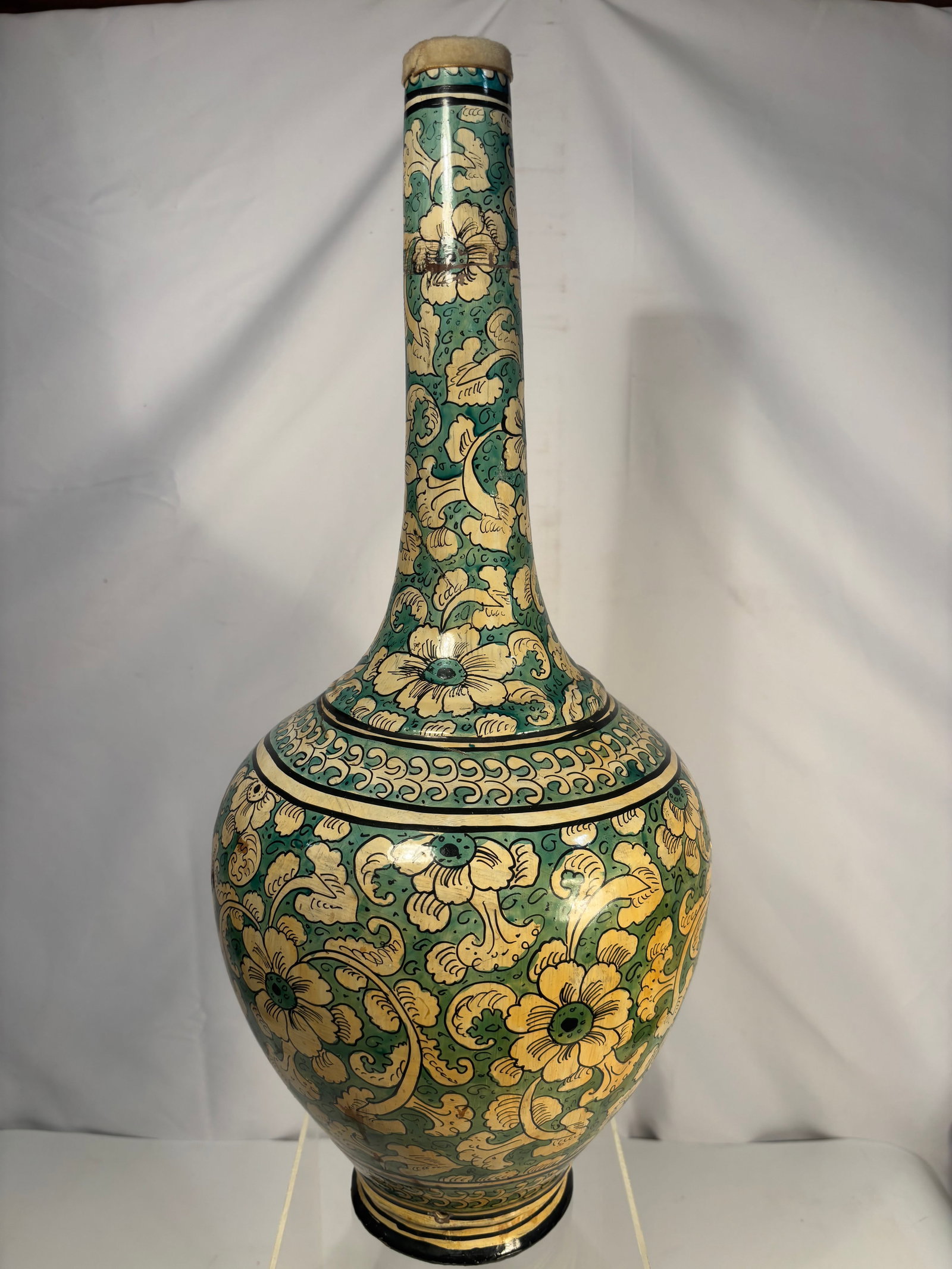 A Large Asian Ceramic Bottle Vase, Green Floral Ground, 21 In.: A large Asian decorative ceramic bottle vase, of elongated bottle form with tall cylindrical neck and rounded body, decorated throughout with a green ground and cream floral scrolling motifs accented 