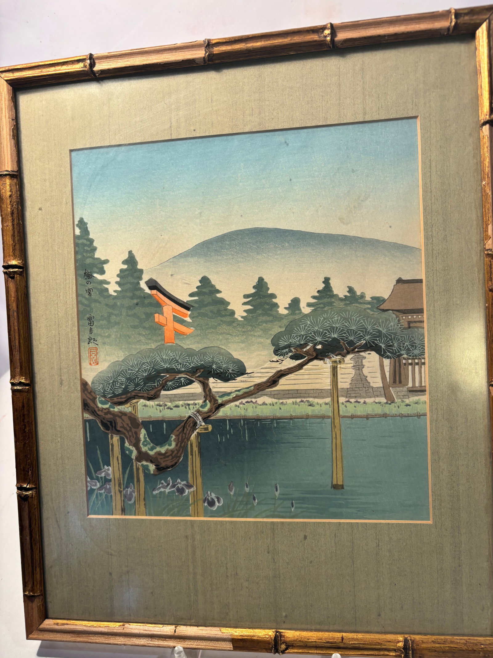 Tokuriki Tomikichiro (1902–2000) ;Japanese Woodblock Print “Umenomiya Shrine??, Framed: A vintage Japanese woodblock print depicting Umenomiya Shrine in Kyoto, featuring a red torii gate, iris pond, and sculpted pine in the foreground with distant hills beyond.The composition and printin